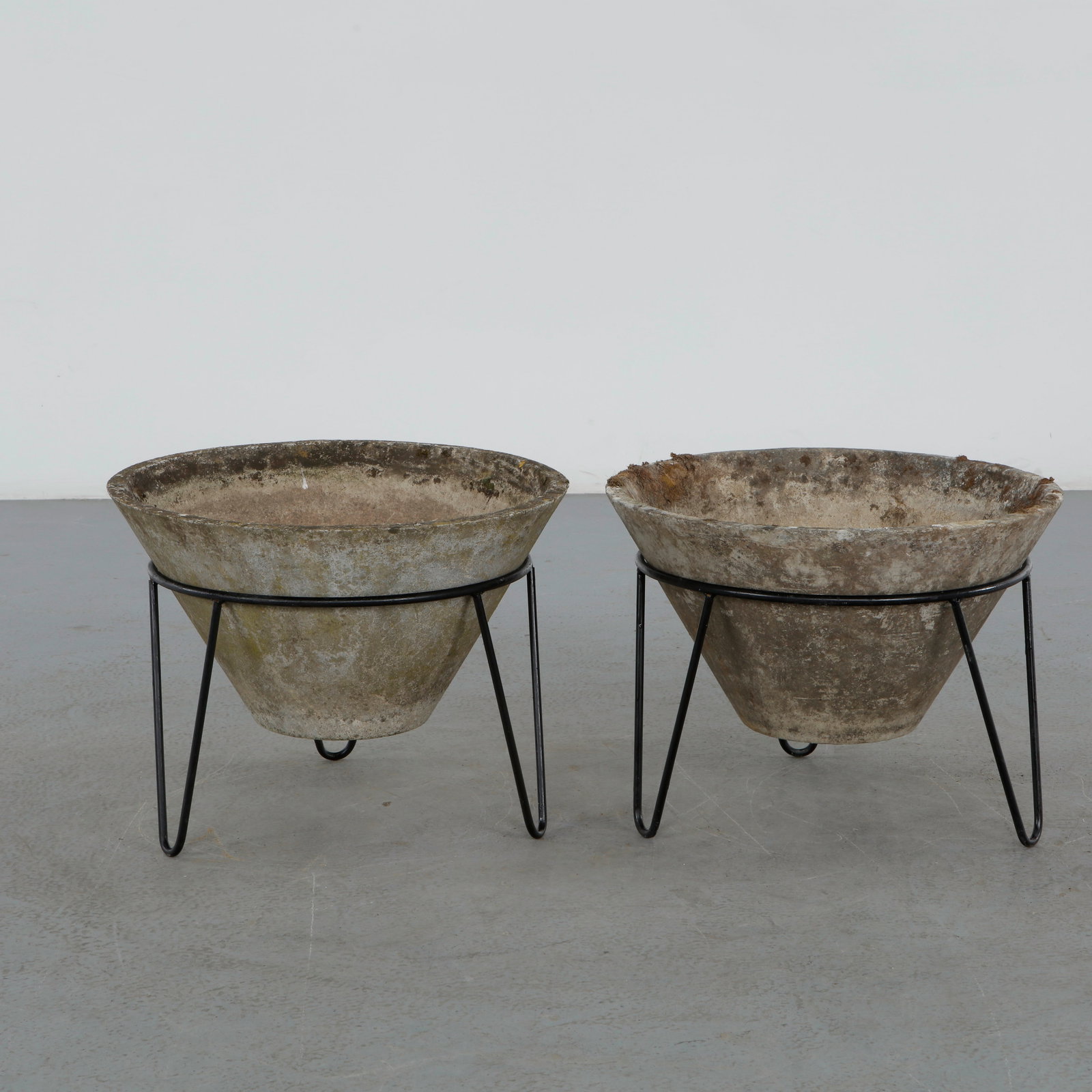 Willy Guhl, Pair of Conical Planters on Stands, 1960s: Iconic Willy Guhl silhouettes in compact form, these conical planters rest atop minimalistic metal stands, weathered yet timeless. Height: 17 in. Diameter: 22 in.