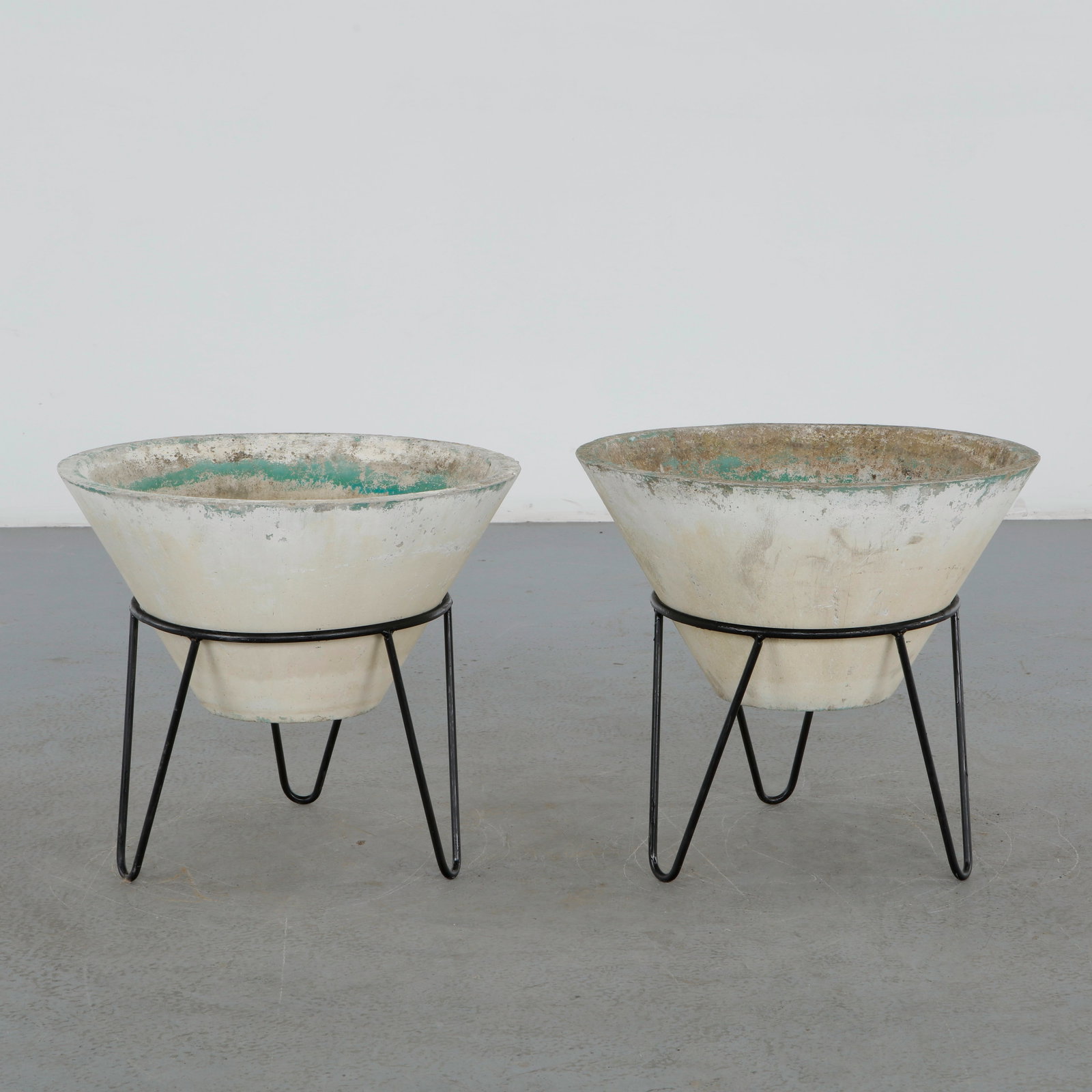 Willy Guhl, Pair of Conical Planters on Stands, 1960s: Iconic Willy Guhl silhouettes in compact form, these conical planters rest atop minimalistic metal stands, weathered yet timeless. Height: 19.5 in. Diameter: 22 in.