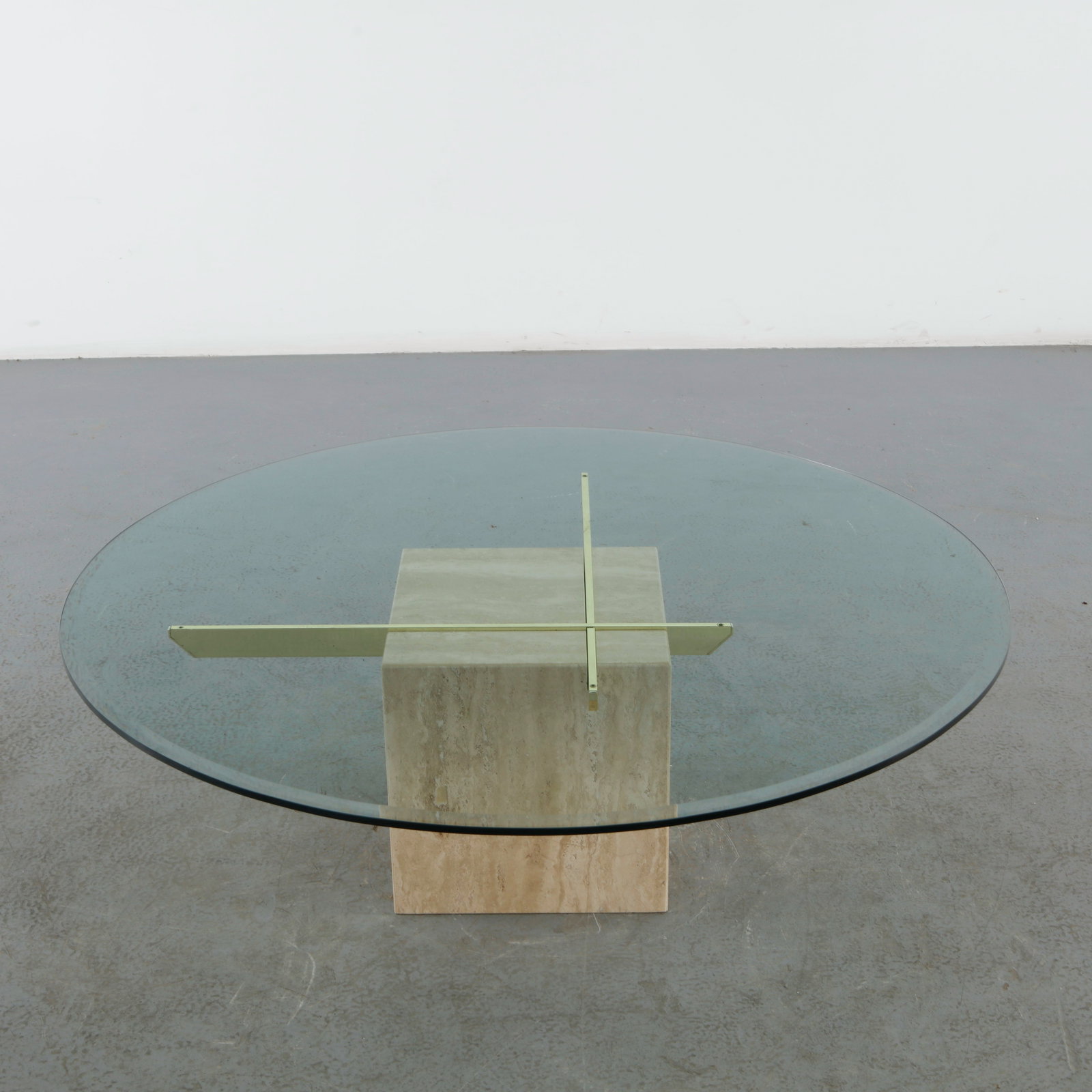 Artedi, Large Round Travertine and Glass and Brass Coffee Table, 1970s: Large coffee table by Artedi featuring a substantial round glass top supported by a sculptural travertine pedestal and brass accents. A sophisticated composition representative of 1970s Italian-inspir