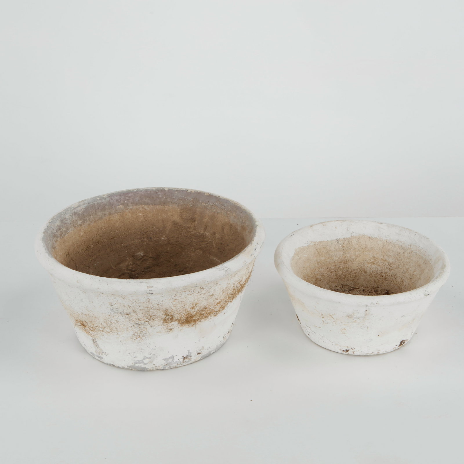 Grandon Fres, Pair of Concrete Round Planters, 1960s: A pair of hand-cast concrete planters by Grandon Fres, featuring a clean, tapered silhouette with a beautifully weathered surface. Elegant examples of French garden design, ideal for both indoor and o