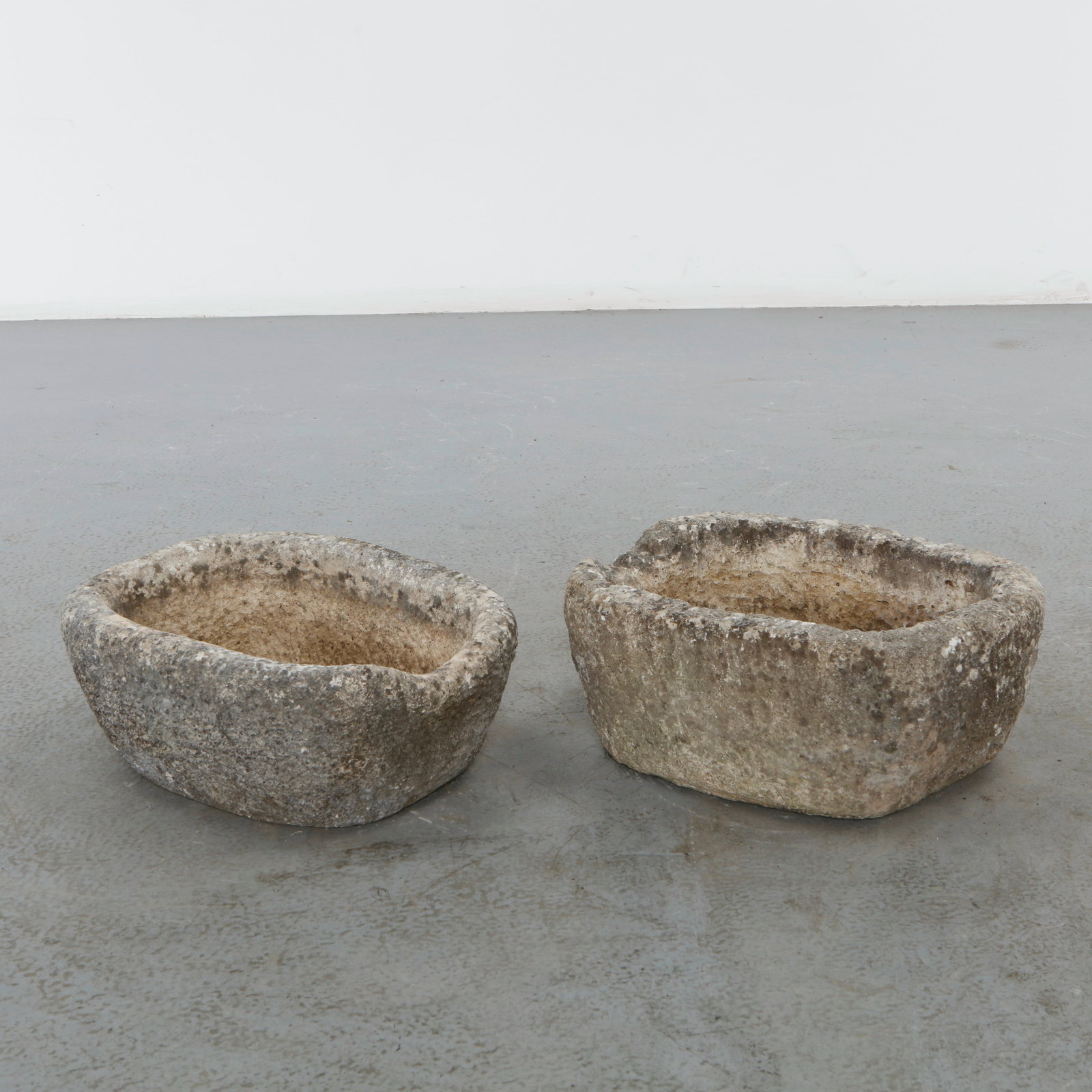 Pair of 19th Century Stone Trough Planters: Pair of hand-carved stone basins featuring organic rounded forms and richly weathered surfaces acquired through decades of outdoor exposure. Originally conceived for utilitarian use, they now possess 