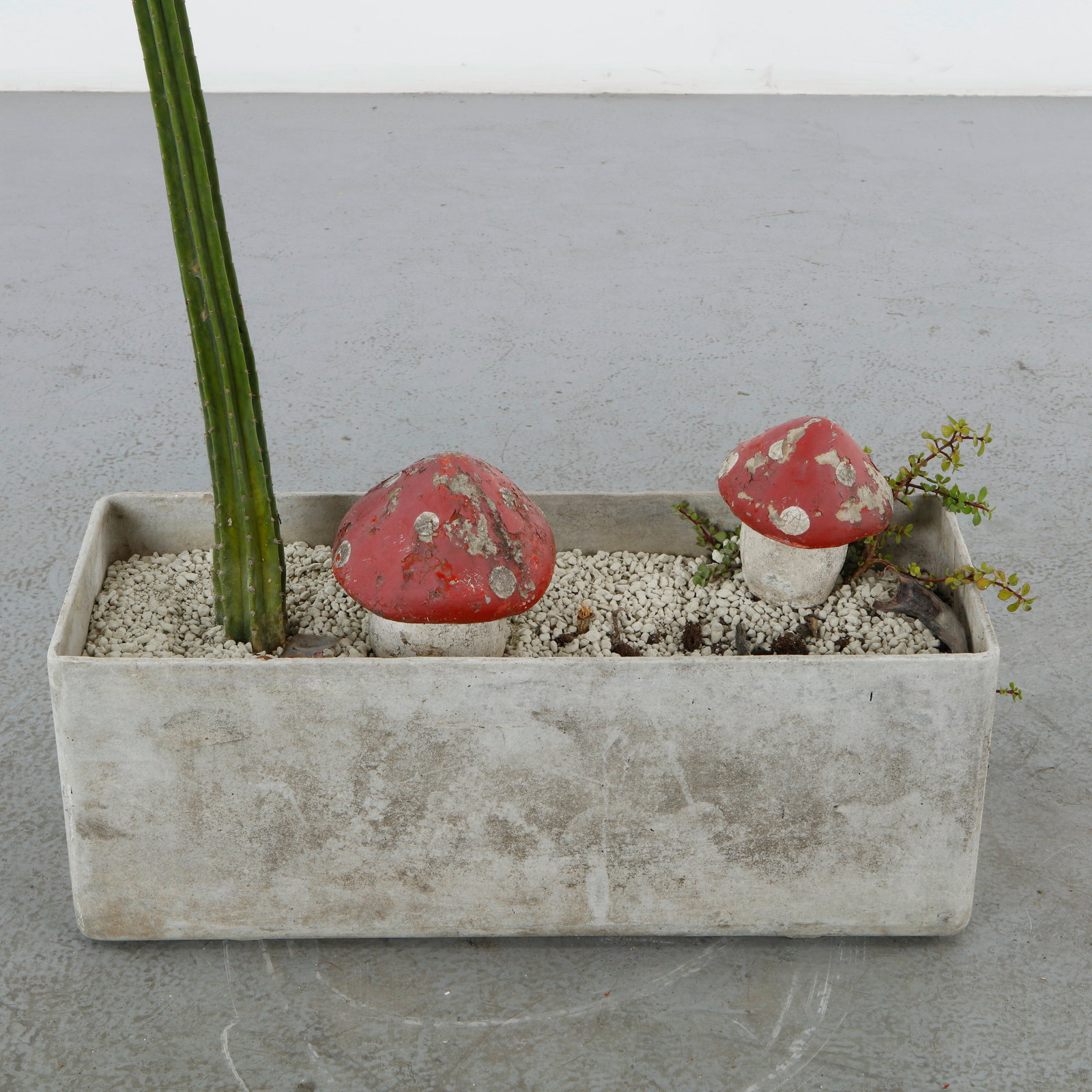 Pair of Weathered Composite Stone Garden Mushrooms: Europe, mid-20th century. A small pair of garden ornaments modeled as toadstools, with red-painted domed caps over white bulbous stems. Old worn paint with pleasing losses throughout.