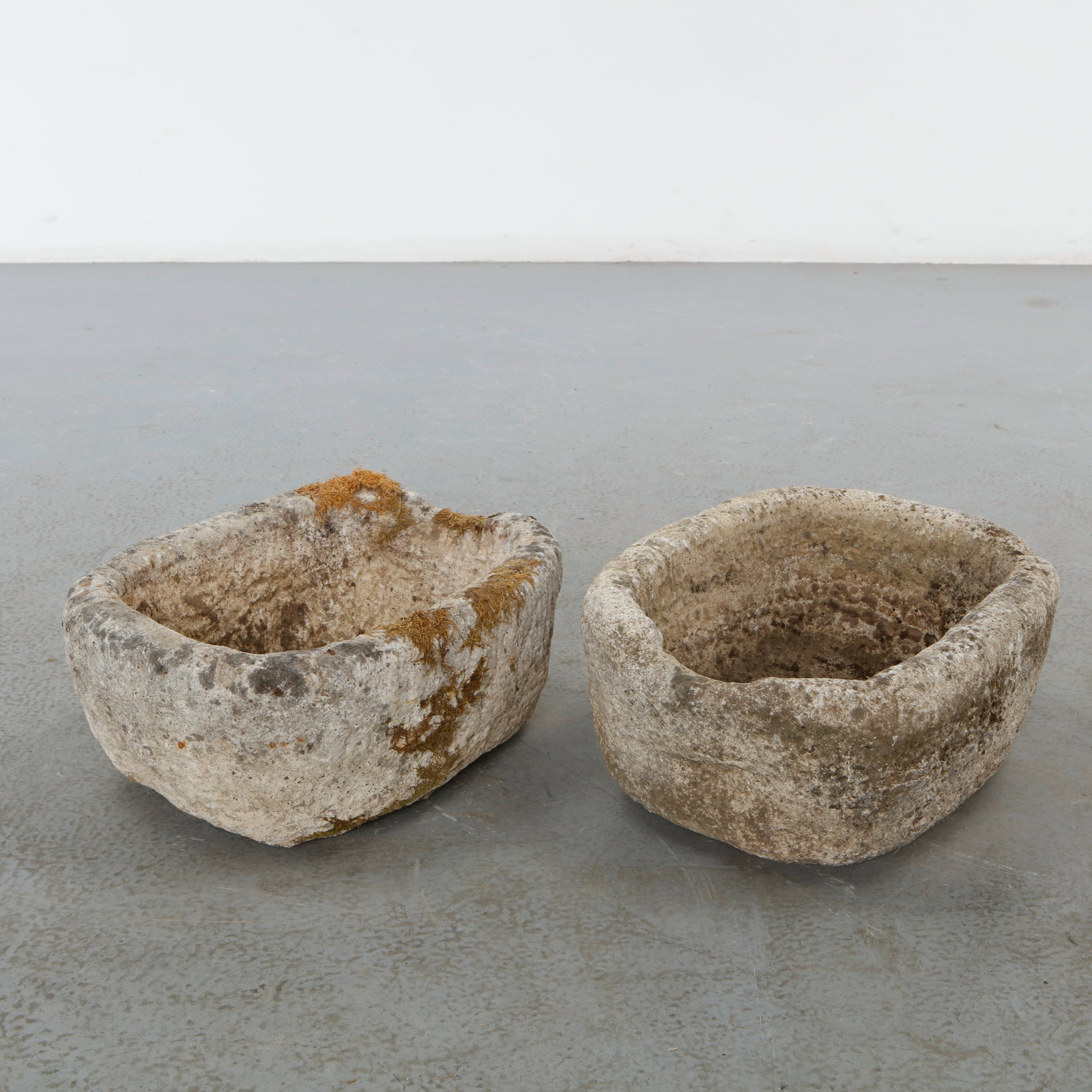 Pair of 19th Century Stone Trough Planters: Pair of hand-carved stone basins featuring organic rounded forms and richly weathered surfaces acquired through decades of outdoor exposure. Originally conceived for utilitarian use, they now possess 