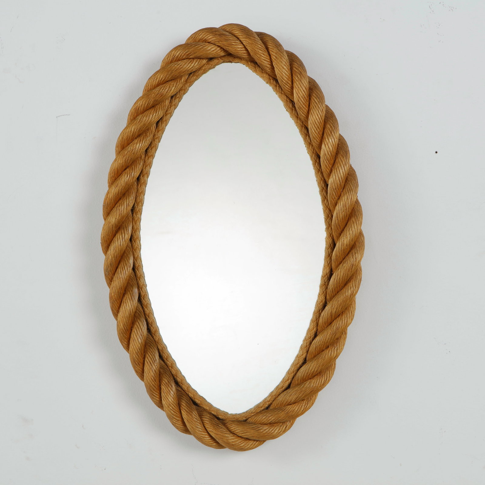 Oval Mirror attributed to Audoux-Minet, 1960s: France, c. 1950s. A hand-wrapped rope mirror with oval glass plate, the frame formed of thick twisted rope in the manner of Adrien Audoux and Paule Minet. Warm natural patina to the rope and mirror
