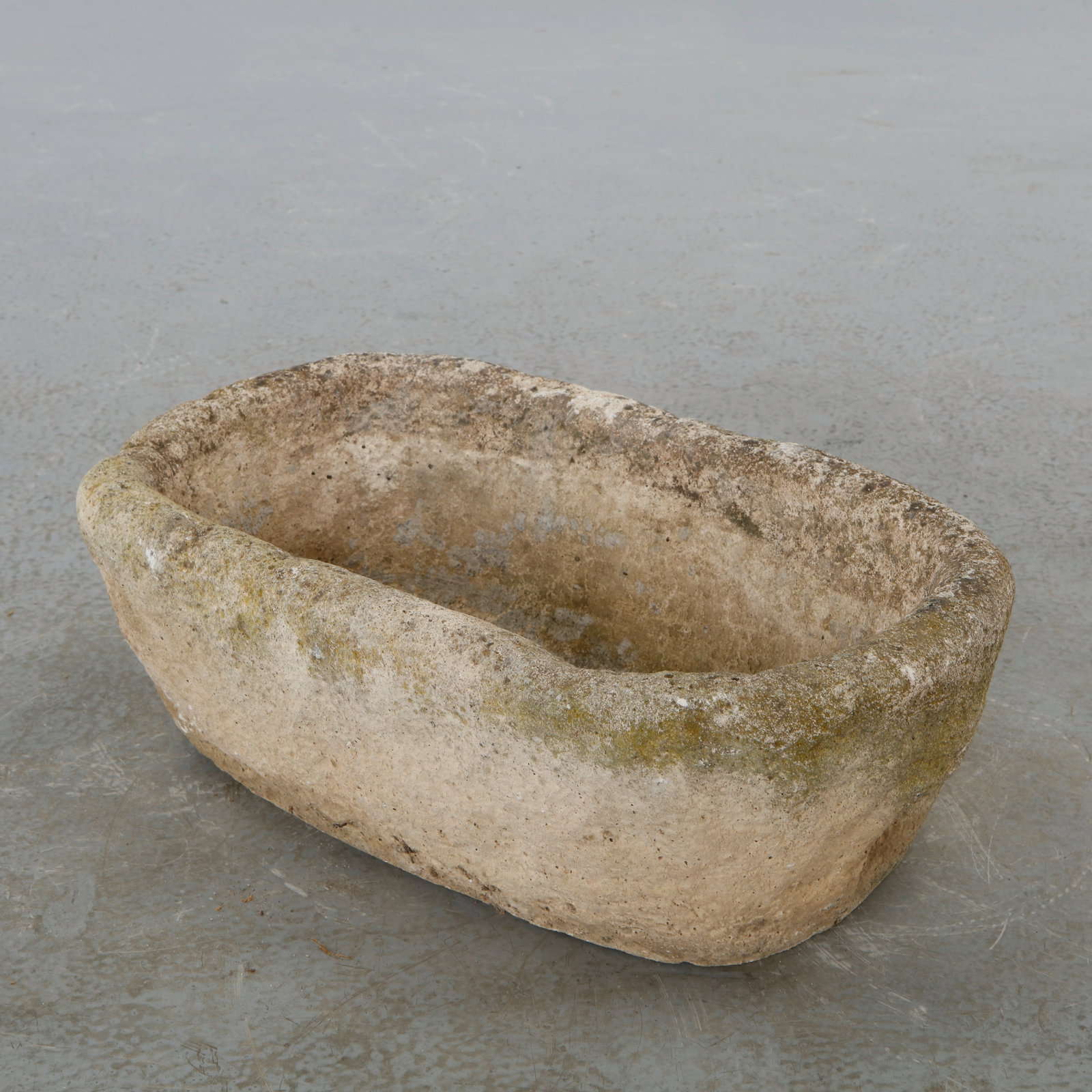 19th Century Stone Trough Planter: A weathered stone trough of oval form with gently rounded corners, hand-carved from a single block and bearing an old incised inscription, AGÂ 15, to the interior floor. The thick, worn rim and
