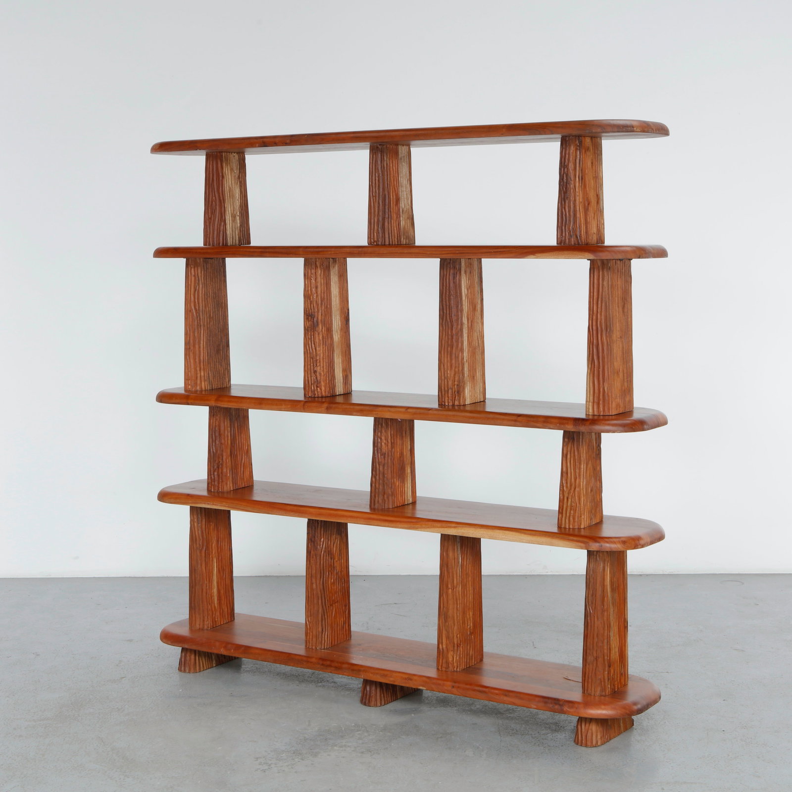 Solid Acacia Wood Bookshelf: Crafted from solid acacia wood, this open bookshelf showcases richly figured grain and deeply sculpted supports that emphasize its architectural character. A bold yet functional piece combining