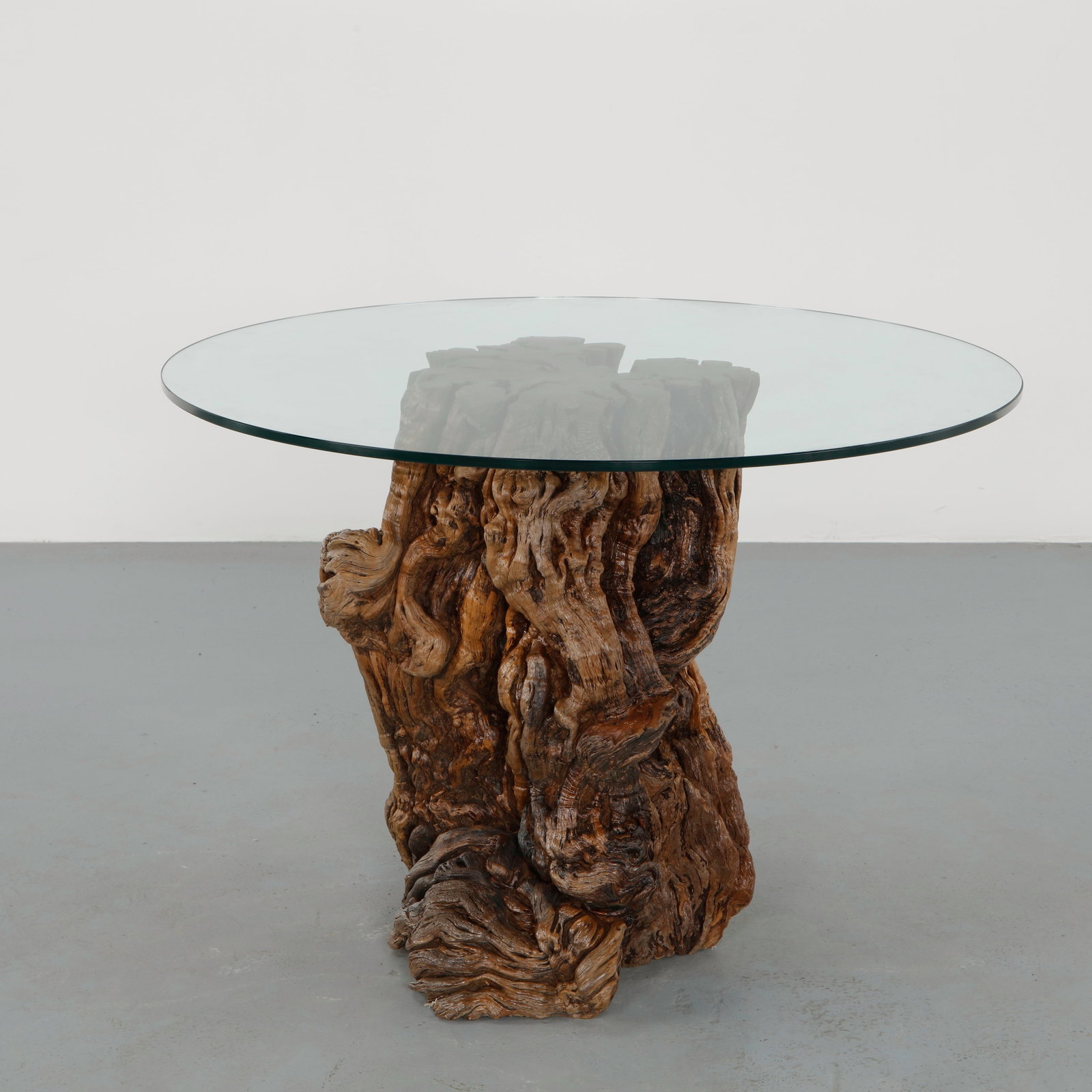 Sculptural Root Wood Pedestal Dining Table with Round Glass Top, 1970s: Composed of a monumental root base topped with a circular glass surface, the table celebrates the natural sculptural character of the wood. The expressive grain and twisting forms create a powerful or