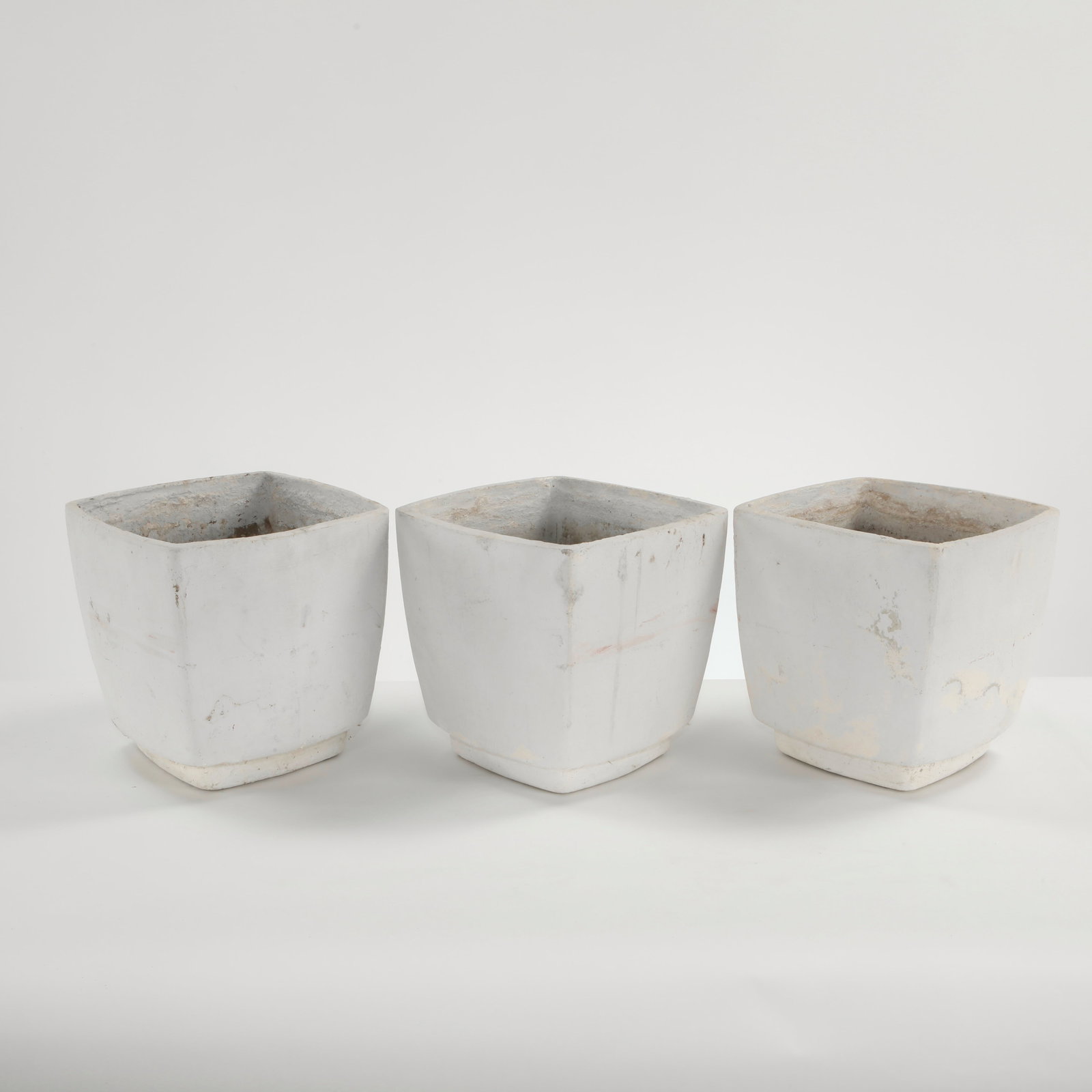 Willy Guhl, Set of Three White Concrete Planters, 1960s: A refined set of three molded concrete planters executed in white cement, featuring crisp geometric profiles and subtly tapered forms. A rare modular ensemble exemplifying Guhl mastery of sculptural r