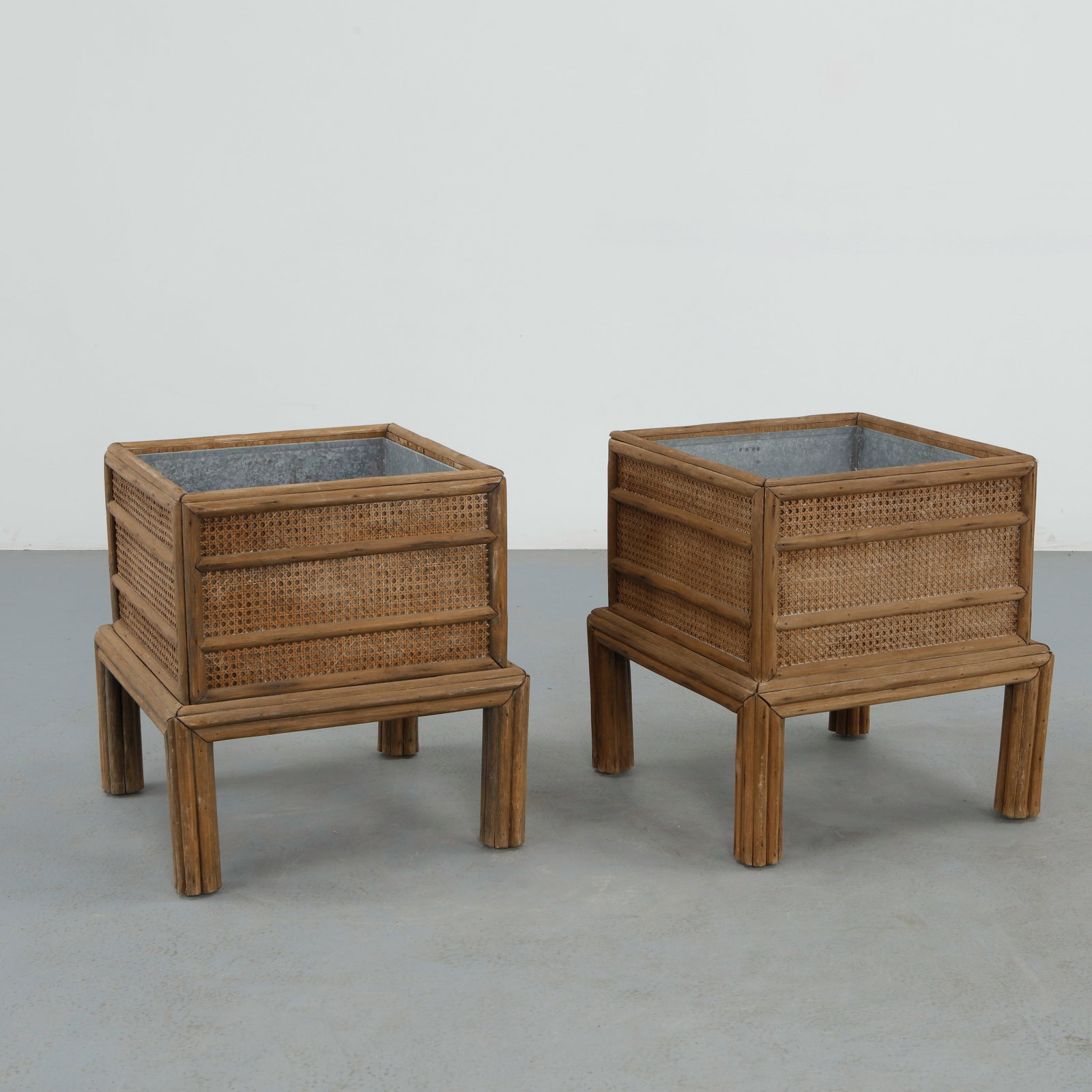 McGuire Furniture Company, Pair of Bamboo and Cane Planters, 1970s: Pair of elevated planters by McGuire Furniture Company crafted in bamboo and woven cane with fitted metal liners. Their architectural proportions embody the organic modern aesthetic of 1970s interiors