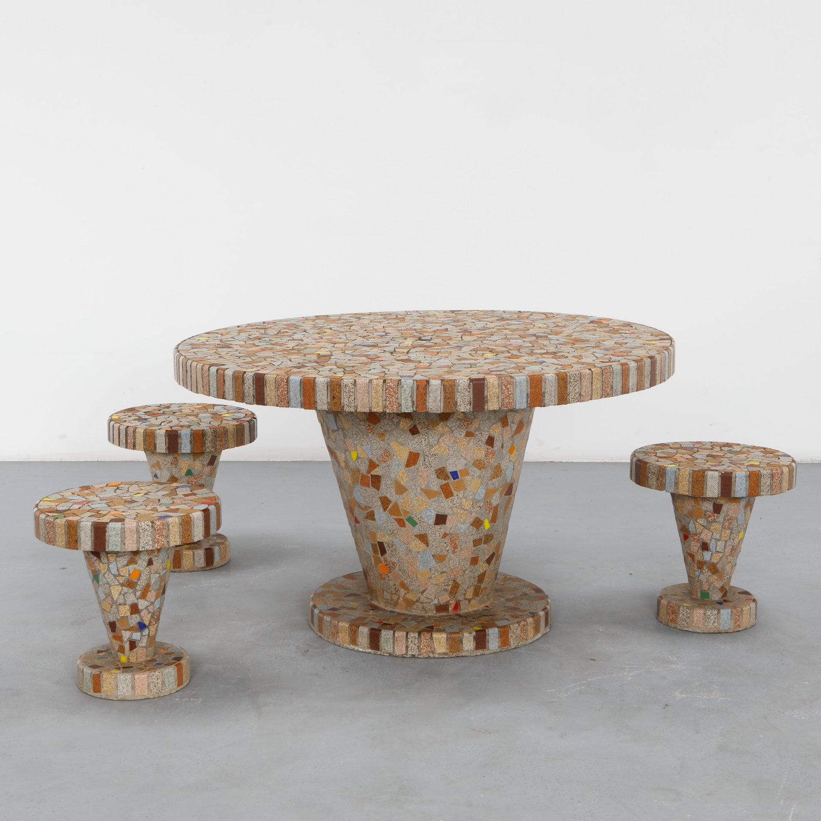 Multicolor Mosaic Dining Set, 1960s: A vibrant round dining table formed as a single piece, its mosaic tiled top flowing directly into a conical mosaic-clad base rather than resting on a separate pedestal. The multicolor mosaic is laid i