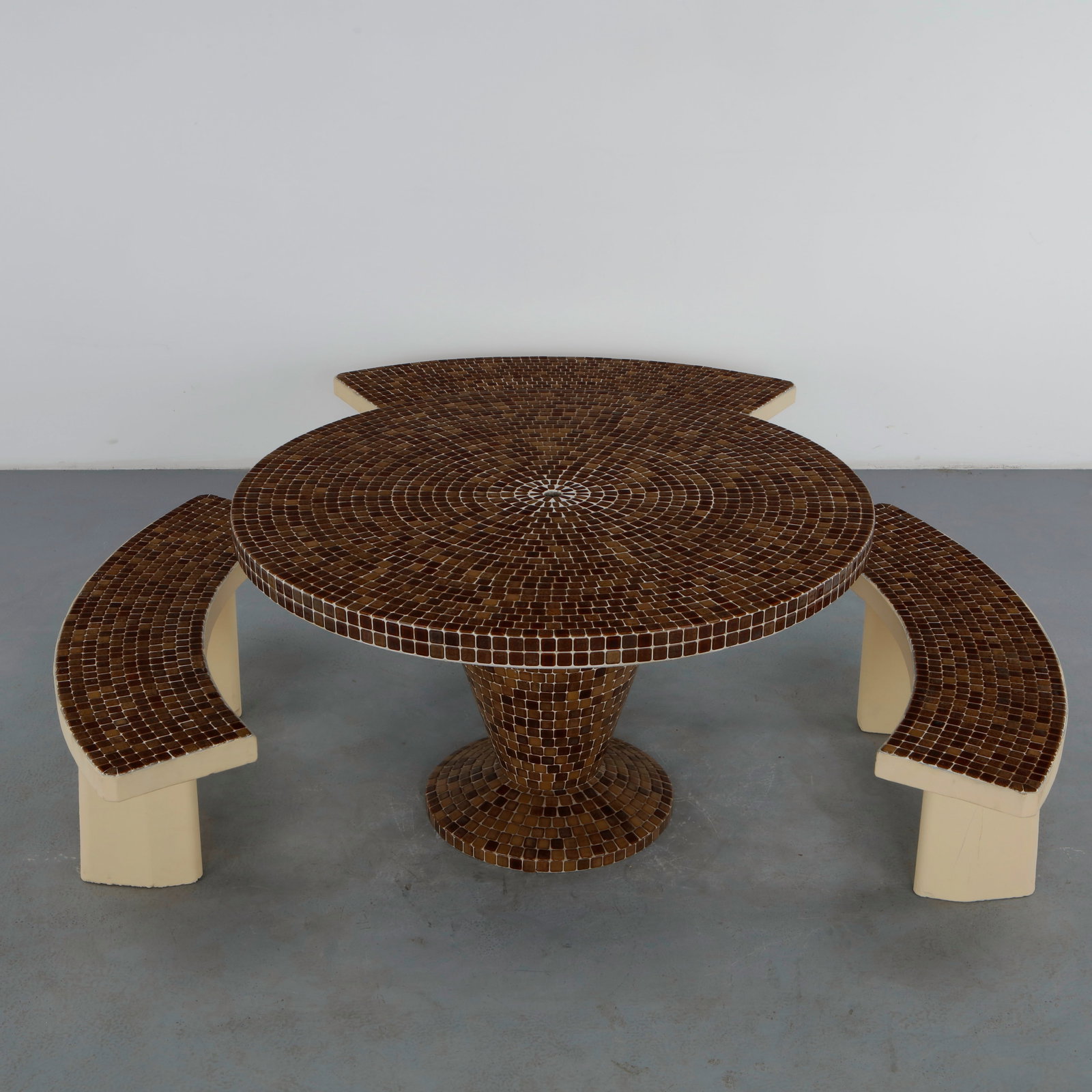 Brown Mosaic Outdoor Dining Set, 1960s: A round outdoor dining table with a tiled brown mosaic top and matching conical pedestal base, accompanied by three curved benches in cream-painted concrete topped with the same mosaic tile. A strikin