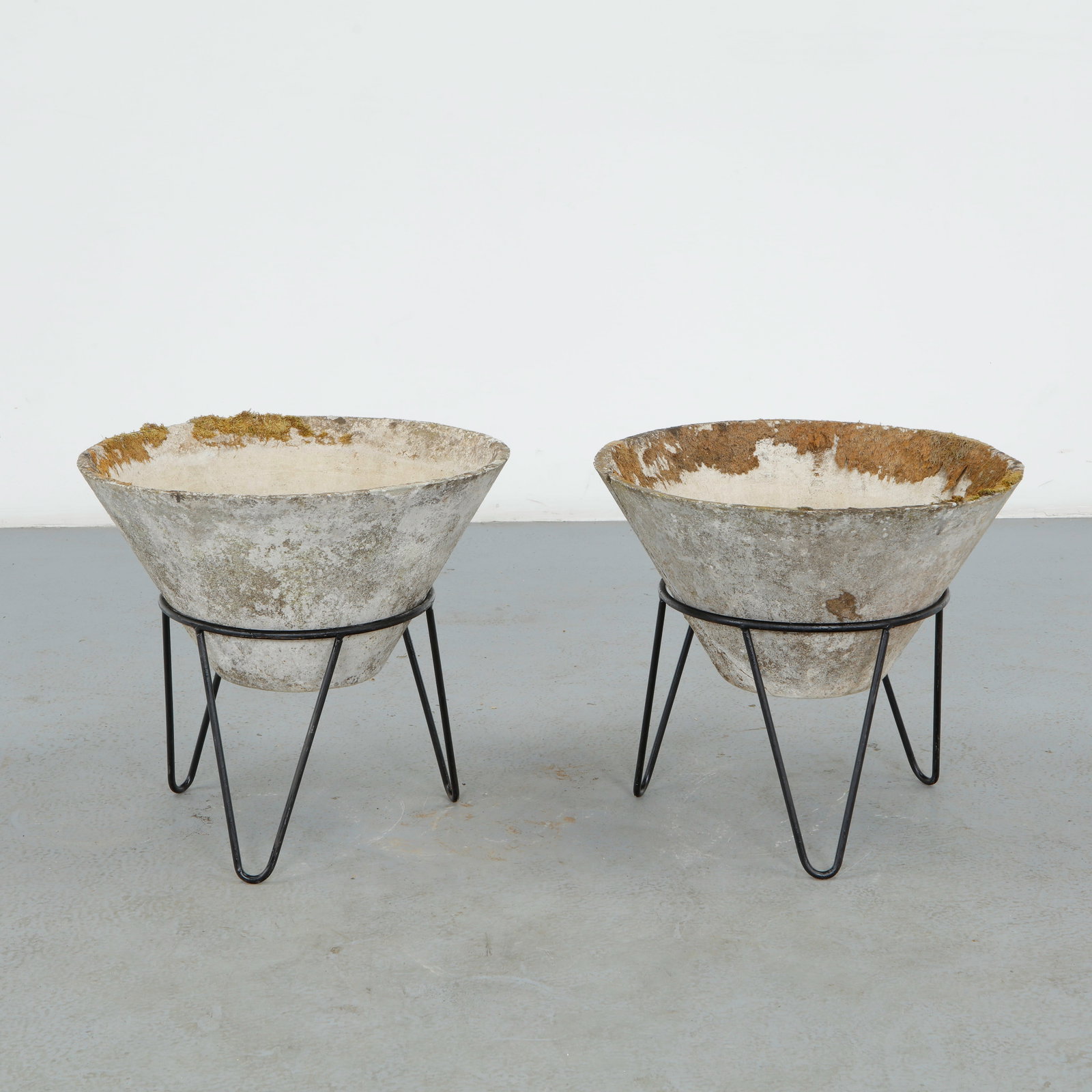 Willy Guhl, Pair of Conical Planters on Metal Stands, 1960s: Iconic Willy Guhl silhouettes in compact form, these conical planters rest atop minimalistic metal stands, weathered yet timeless. Height: 19.5 in. Diameter: 22 in.