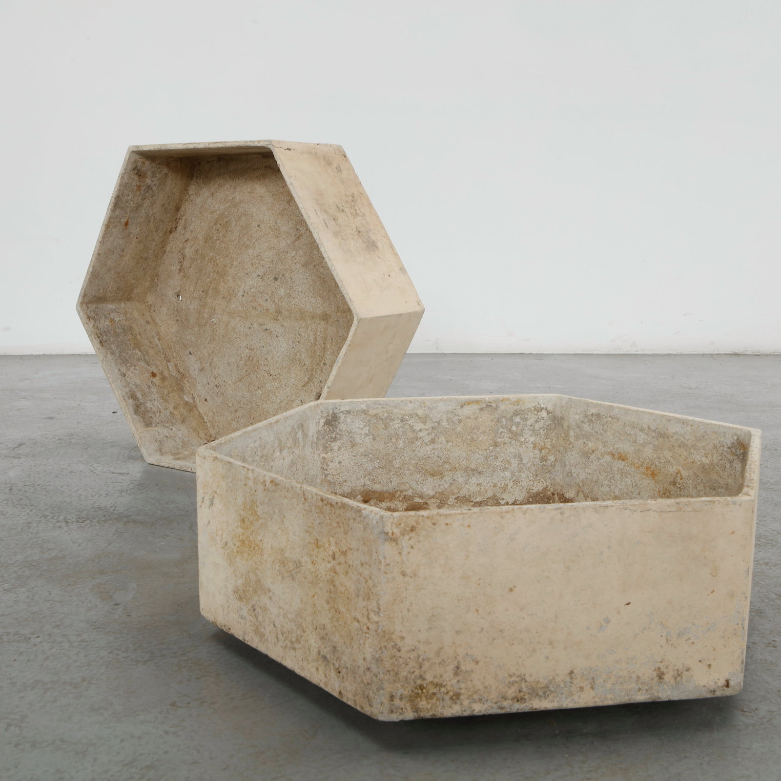 Willy Guhl, Pair of Hexagonal Planters, 1960s: Crafted in fiber cement, this pair of hexagonal planters exemplifies Willy Guhl restrained approach to sculptural outdoor design. Their faceted geometric form and naturally weathered surface highlight