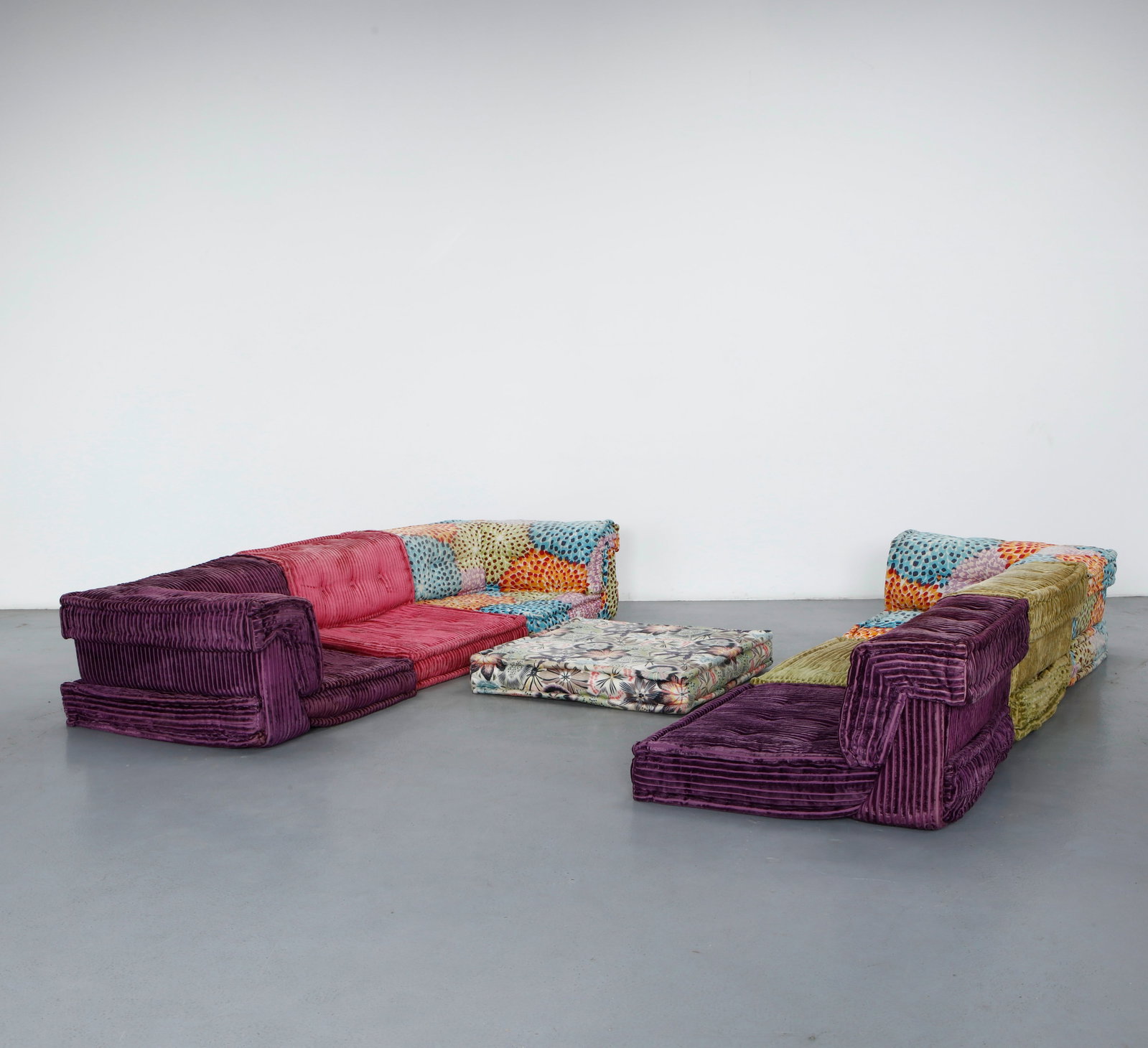 Hans Hopfer for Roche Bobois, 13-Piece Missoni Mah Jong Modular Sofa, 2000s: A 13-piece Mah Jong system upholstered in Missoni patterned corduroy, mixing floral, dotted, and striped panels in magenta, plum, and olive. Each low, tufted element is freely reconfigurable, reflecti