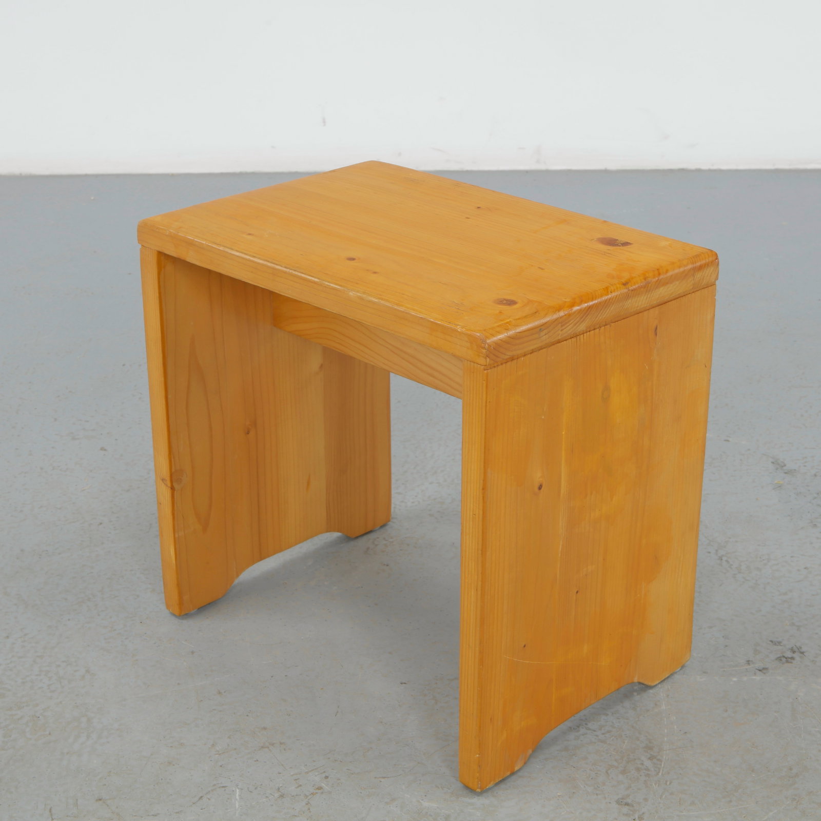 Charlotte Perriand for Les Arcs 1600, Pine Stool, 1960s: A compact solid pine stool, rectangular top on two plank legs with simple through construction. Warm, honeyed patina and pared back geometry. Height: 17 in. Length: 18 in. Width: 12 in.