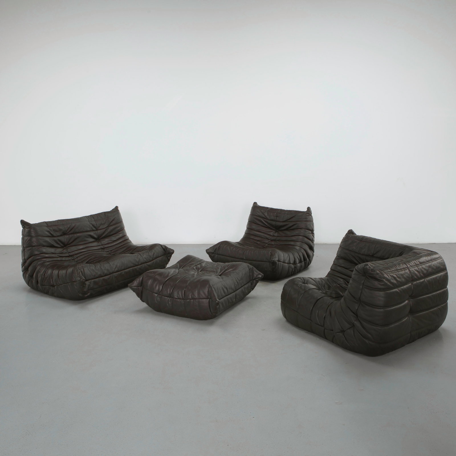 Michel Ducaroy for Ligne Roset, Dark Brown Togo Living Room, 2011: Executed in supple dark brown leather, this modular Togo living room exemplifies Michel Ducaroy iconic all-foam design, celebrated for its sculptural silhouette and exceptional comfort. Comprising mul