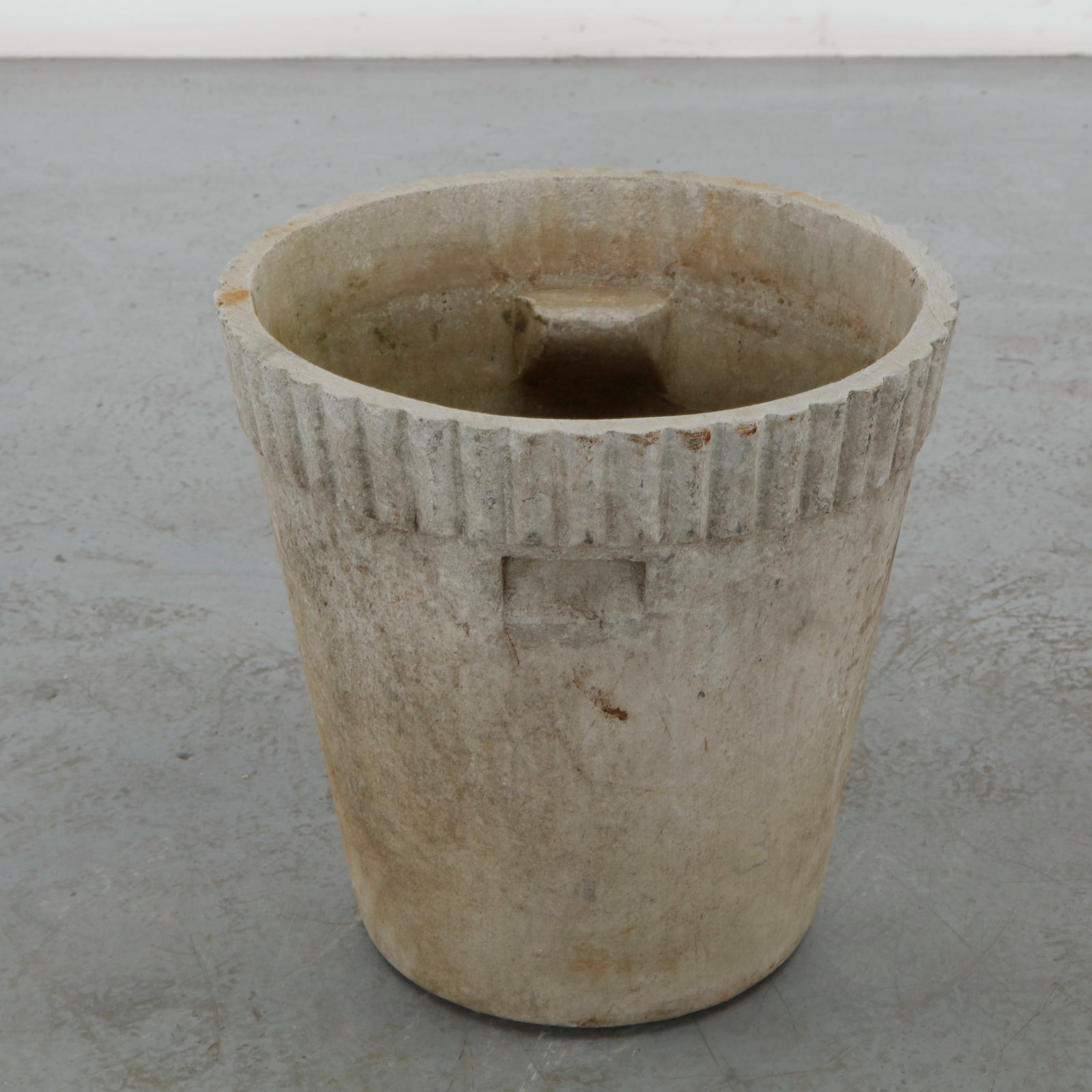 Willy Guhl, Large Round Planter, 1960s: A large round planter in fiber cement, its cylindrical body rising to a fluted rim band. Cream surface with heavy vertical staining to the front. Height: 15 in. Diameter: 15 in.