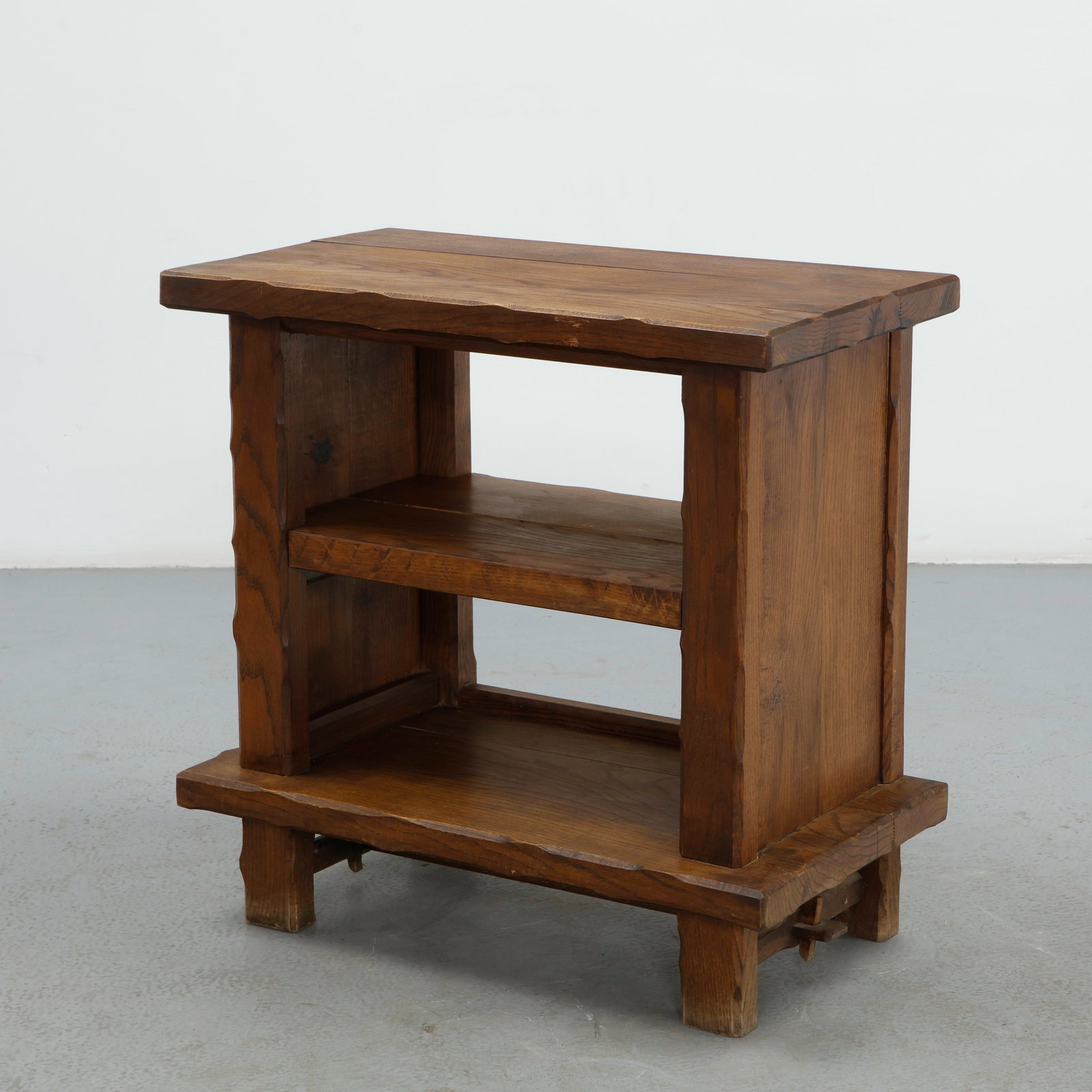 Olavi Hanninen, Brutalist Oak Side Table, 1960s: Constructed from solid oak, this side table features a notched, wave edged top above two open shelves, raised on tapering trestle legs joined by a through stretcher secured with a wedged tenon. The ru