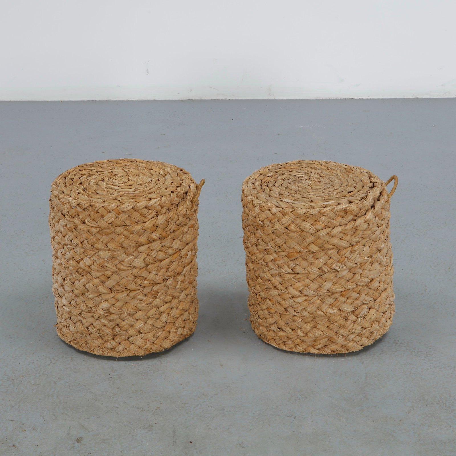 Pair of Rope Stools in the Style of Audoux Minet, 1960s: A pair of cylindrical stools entirely hand-woven in natural rope, each with a small woven loop handle for carrying, a simple, tactile design in the naturalistic spirit of Audoux Minet. Stool: Height: 