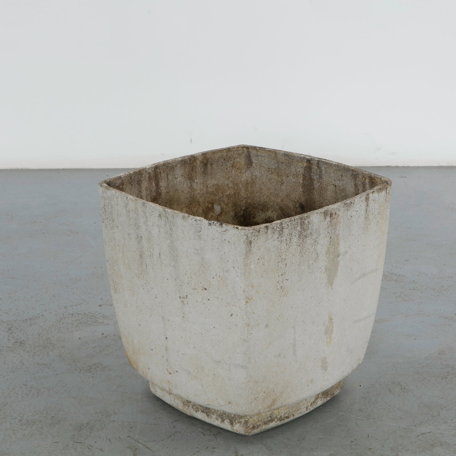 Willy Guhl, Large Square Planter, 1960s: A single planter of rounded square form in fiber cement, tapering to a narrow footed base. Smooth cream surface with light mineral staining. Height: 19,25 in. Length: 19.75 in. Width: 19.75 in.