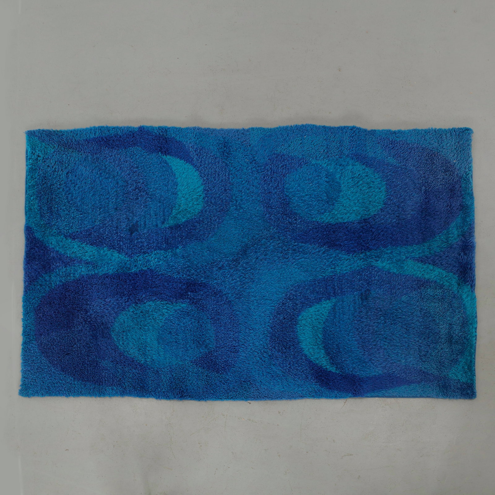 Rya for Finnrya Oy AB, Original Scandinavian Rug, Finland, 1960s: An original handwoven rya rug by Finnrya Oy AB, executed in richly textured wool with a vibrant composition of layered cobalt and turquoise circular motifs. A striking example of Scandinavian textile 
