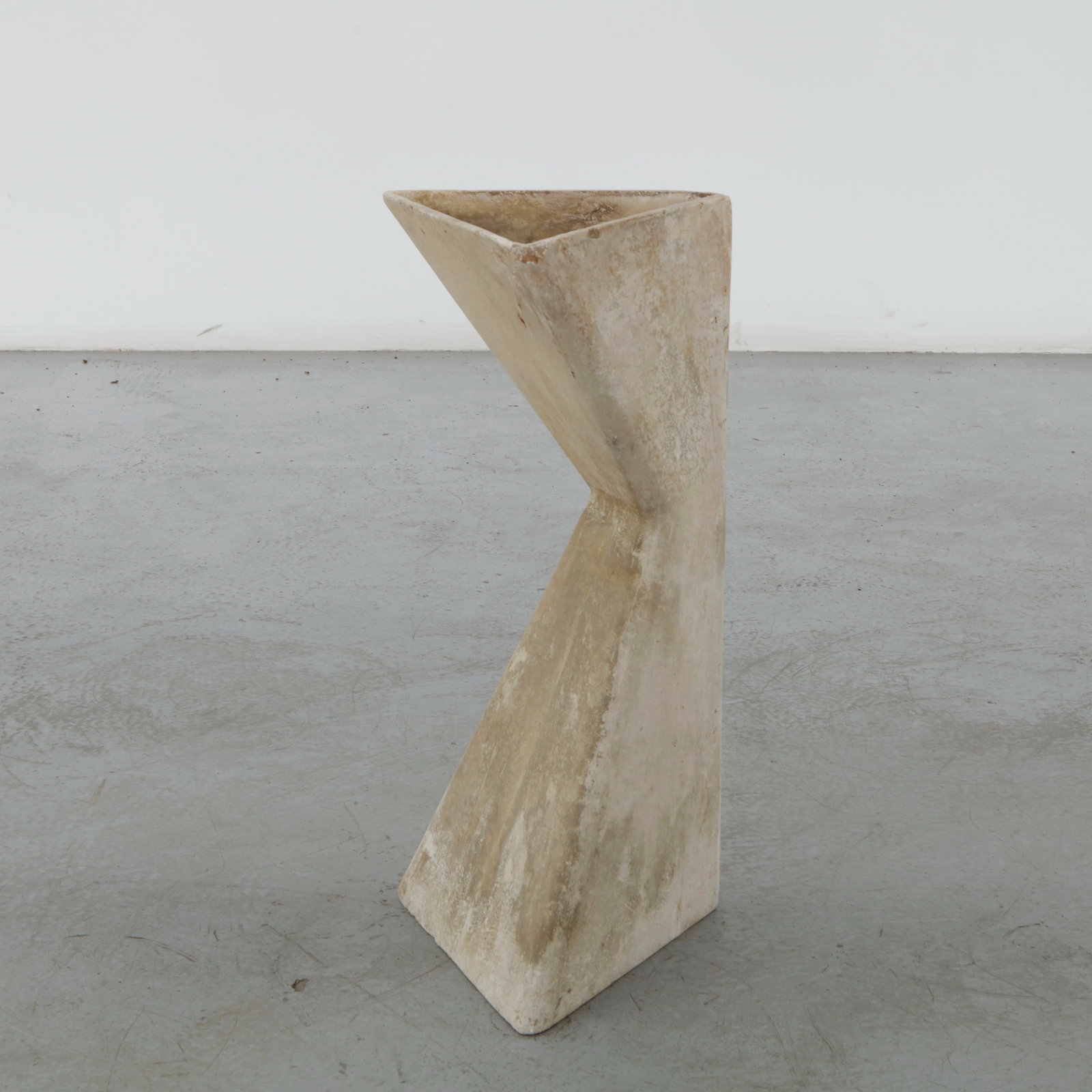 Willy Guhl, Twisted Planter, 1960s: Executed in fiber cement, this sculptural planter embodies Willy Guhl celebrated exploration of form through simple geometric volumes. Its twisted silhouette and naturally weathered surface exemplify 