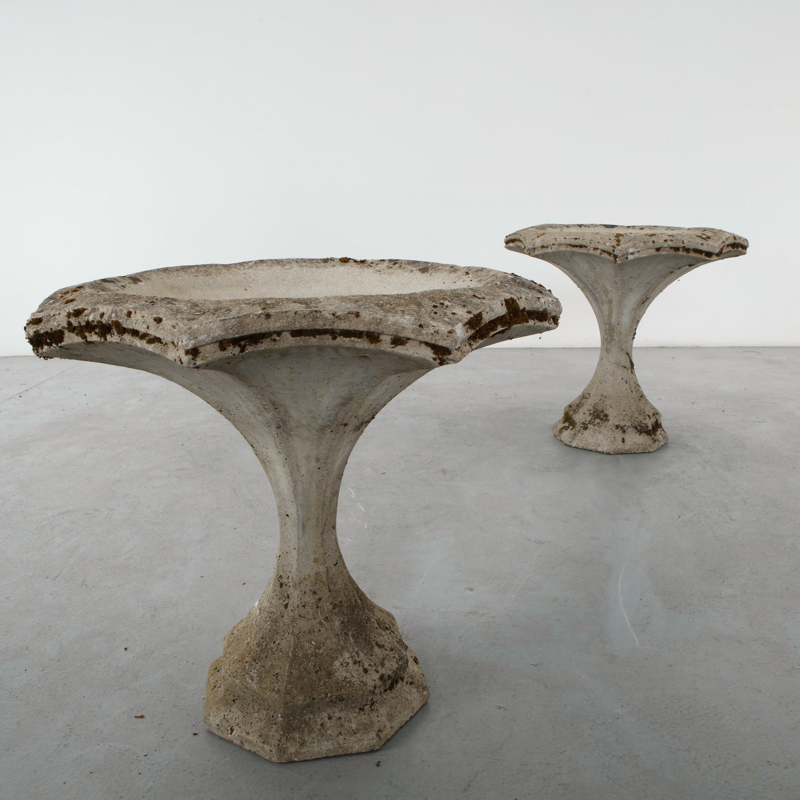 Pair of Monumental Cast Stone Fountains, 1960s: Monumental cast stone fountains of sculptural hourglass form with broad scalloped basins. Their refined proportions and weathered patina create striking focal points for formal gardens and
