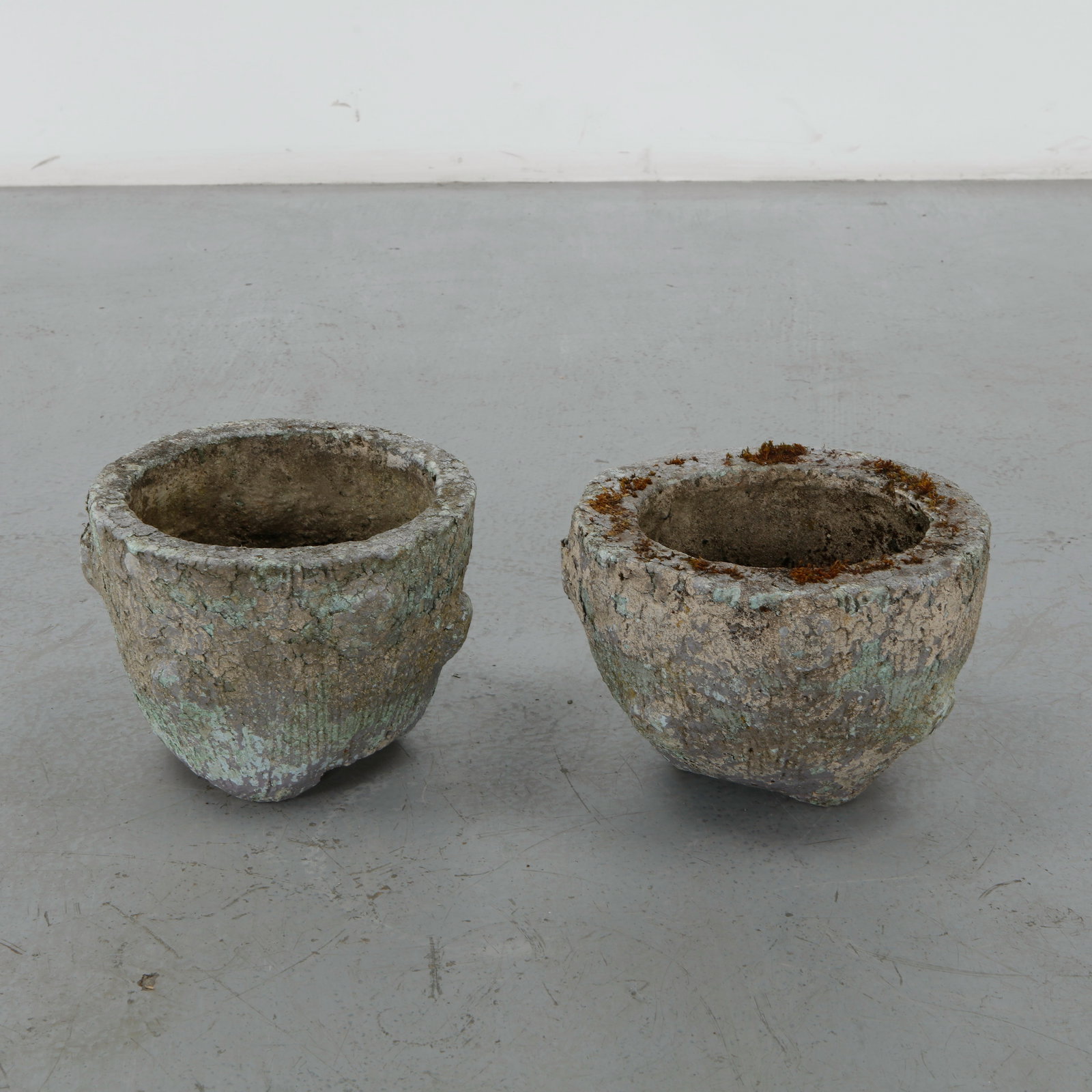 Pair of Faux Bois Round Planters, 1960s: Pair of round cast stone planters with richly textured faux bois surfaces imitating weathered tree bark. Their naturally aged patina and sculptural forms make them refined decorative vessels for both 
