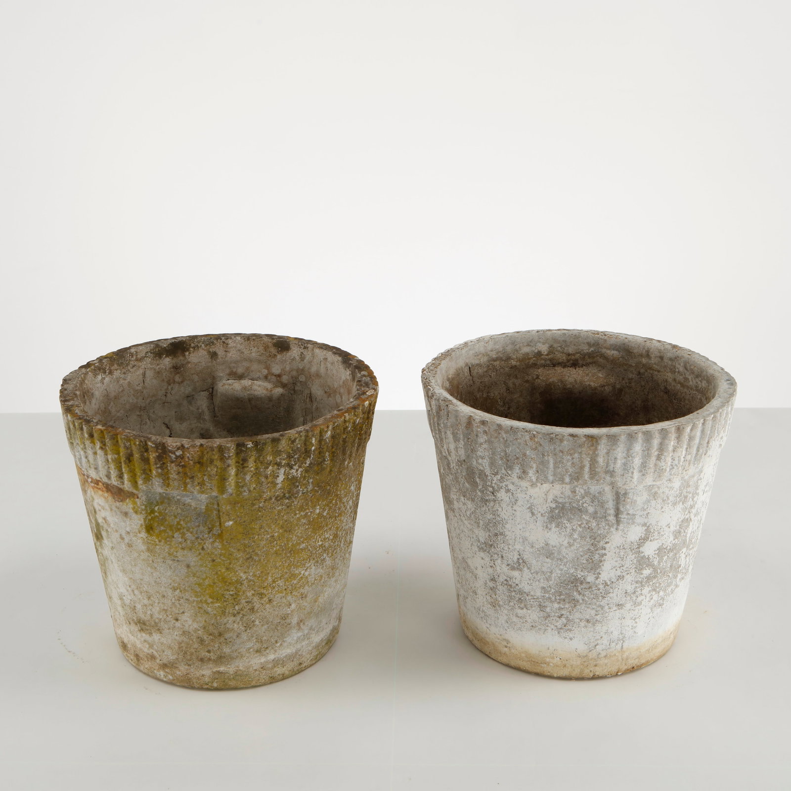 Willy Guhl, Pair of Small Round Planters, 1960s: Classic 1960s round planters by Willy Guhl, with ribbed detailing along the rim. Timeless silhouettes for elegant garden design. Height: 9.5 in. Diameter: 10.5 in.