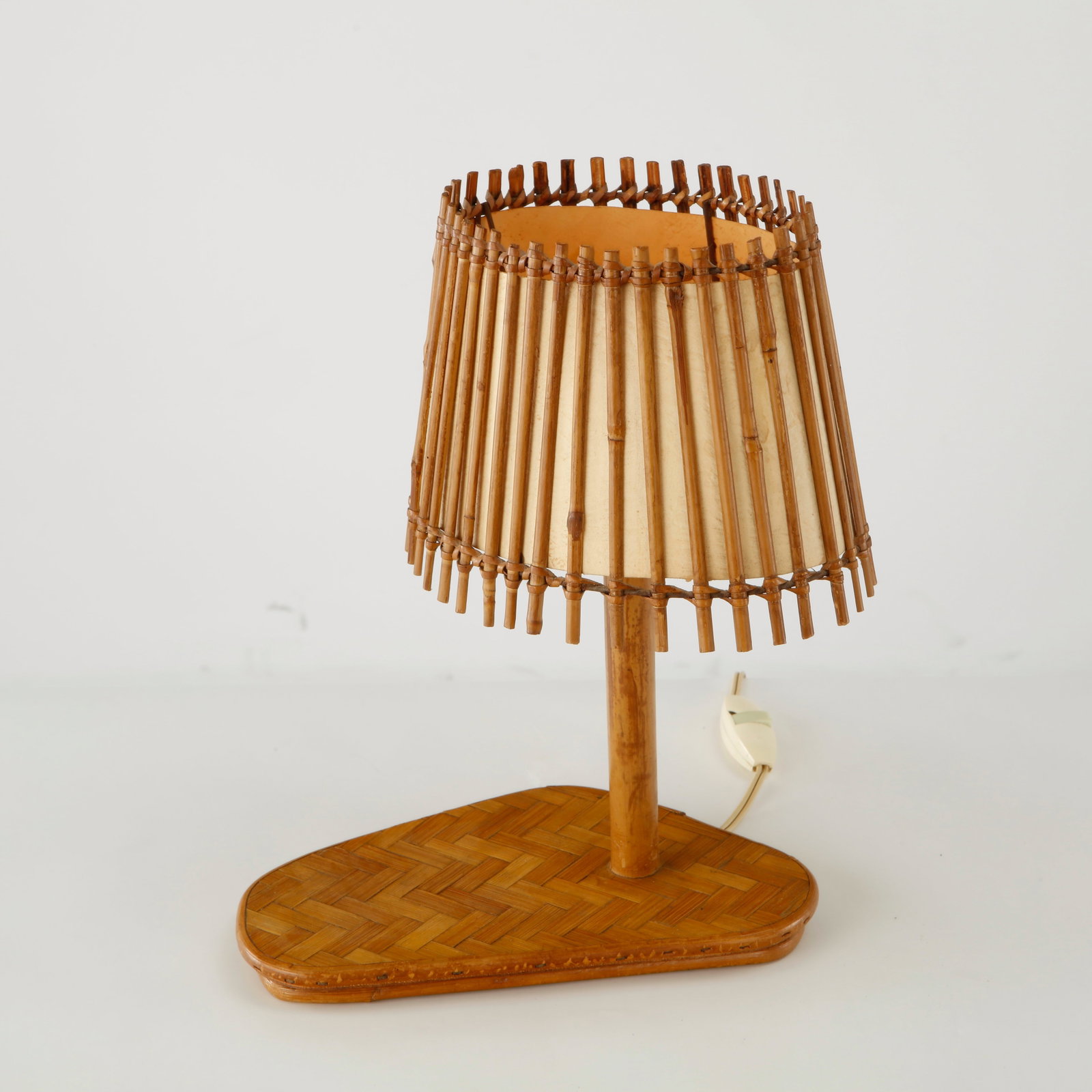 Louis Sognot, Bamboo Table Lamp, France, 1950s: A sculptural bamboo table lamp raised on a woven bamboo base and topped by a geometric openwork shade. The restrained composition highlights Sognot mastery of natural materials and elegant functional 