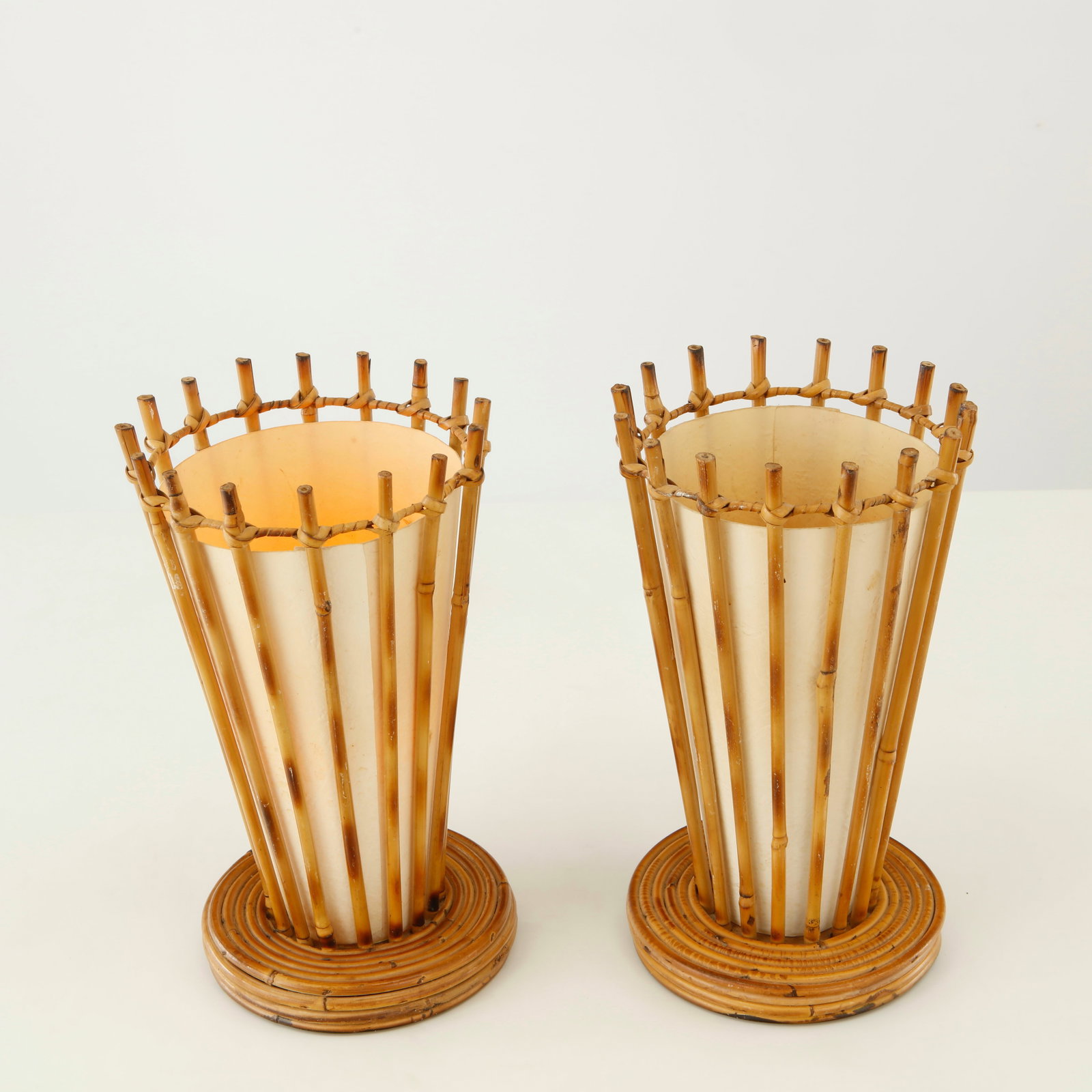 Louis Sognot, Pair of Bamboo Table Lamps, France, 1950s: This elegant pair features tapered bamboo frameworks enclosing parchment diffusers, creating a warm and atmospheric illumination. Their balanced proportions and delicate craftsmanship embody Louis