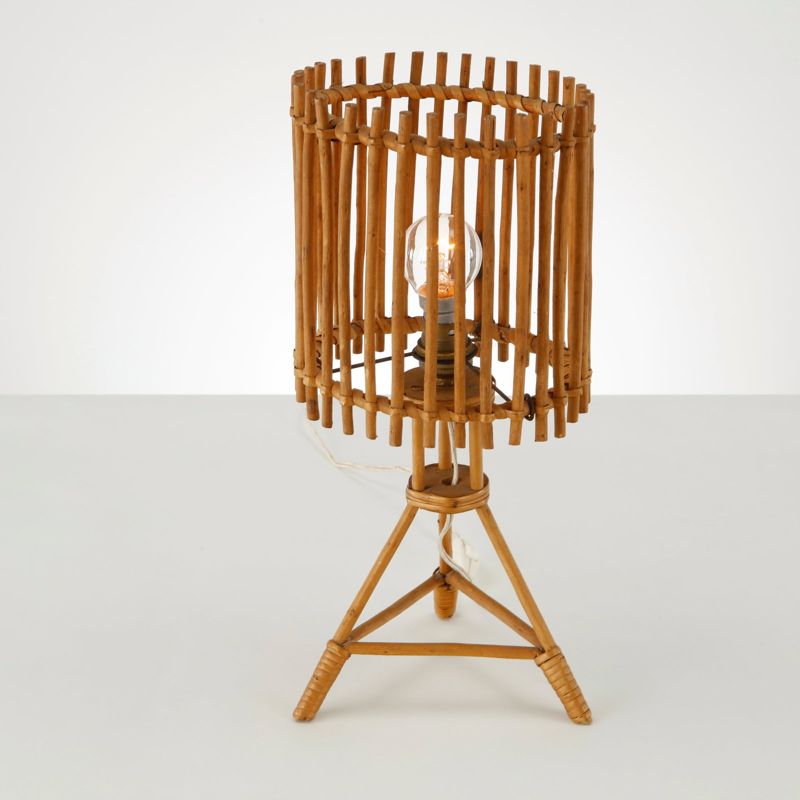 Louis Sognot, Bamboo Tripod Table Lamp, France, 1950s: Crafted in bamboo and rattan with a parchment diffuser, this tripod table lamp exemplifies Louis Sognot celebrated exploration of natural materials. Its airy construction diffuses a warm ambient