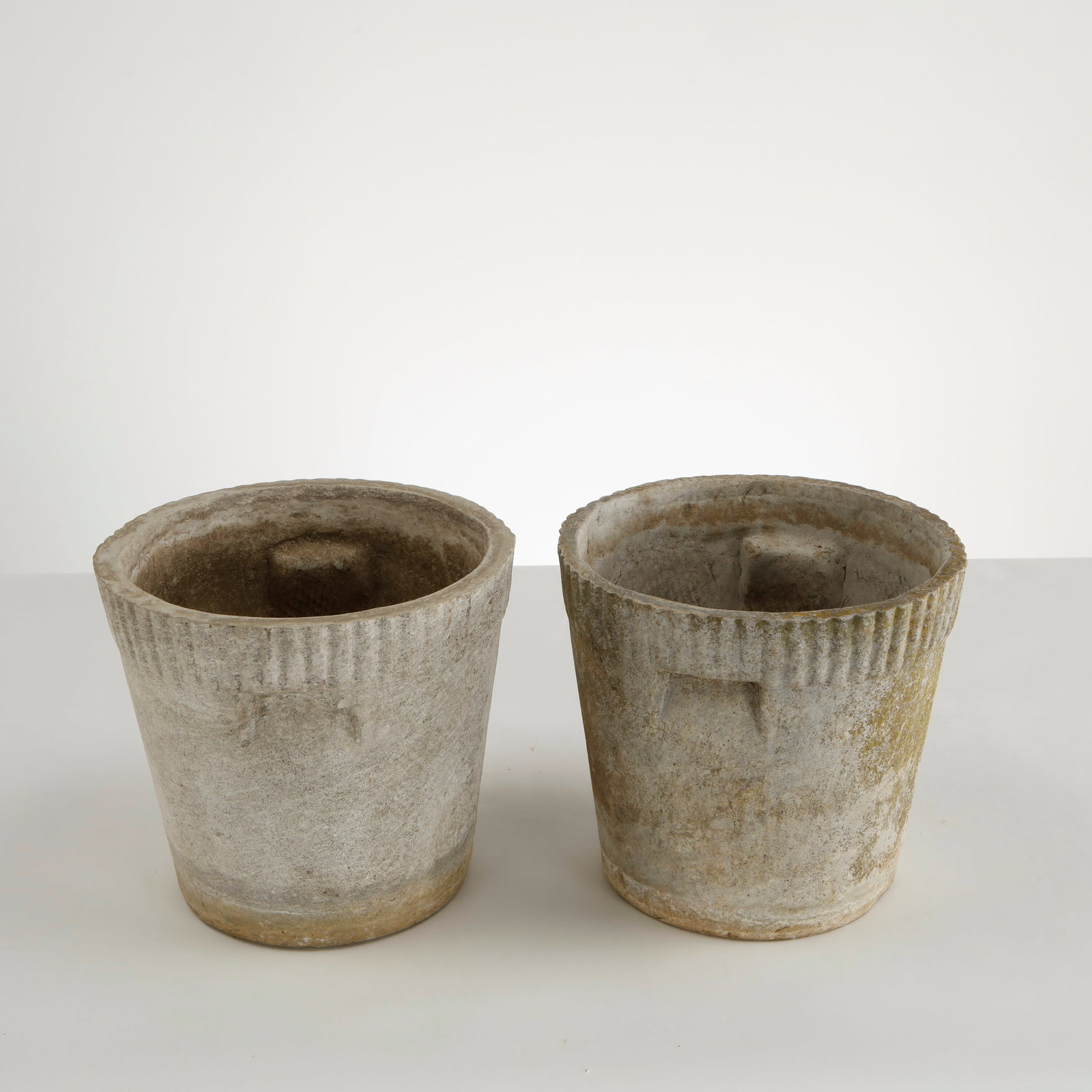 Willy Guhl, Pair of Small Round Planters, 1960s: Classic 1960s round planters by Willy Guhl, with ribbed detailing along the rim. Timeless silhouettes for elegant garden design. Height: 9.5 in. Diameter: 10.5 in.