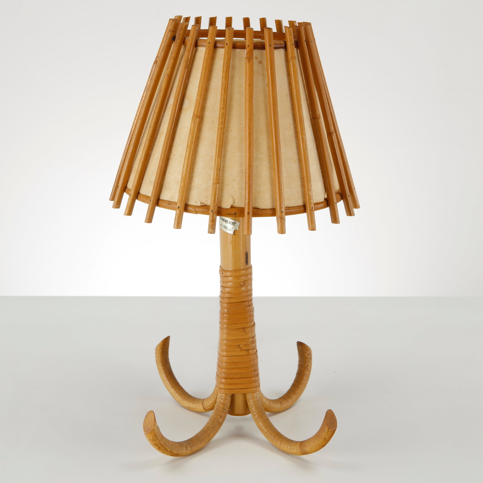 Louis Sognot, Bamboo Table Lamp, France, 1950s: An elegant bamboo table lamp featuring a sculptural four-foot base and an openwork shade surrounding a parchment diffuser. Organic proportions and refined craftsmanship define this distinctive French