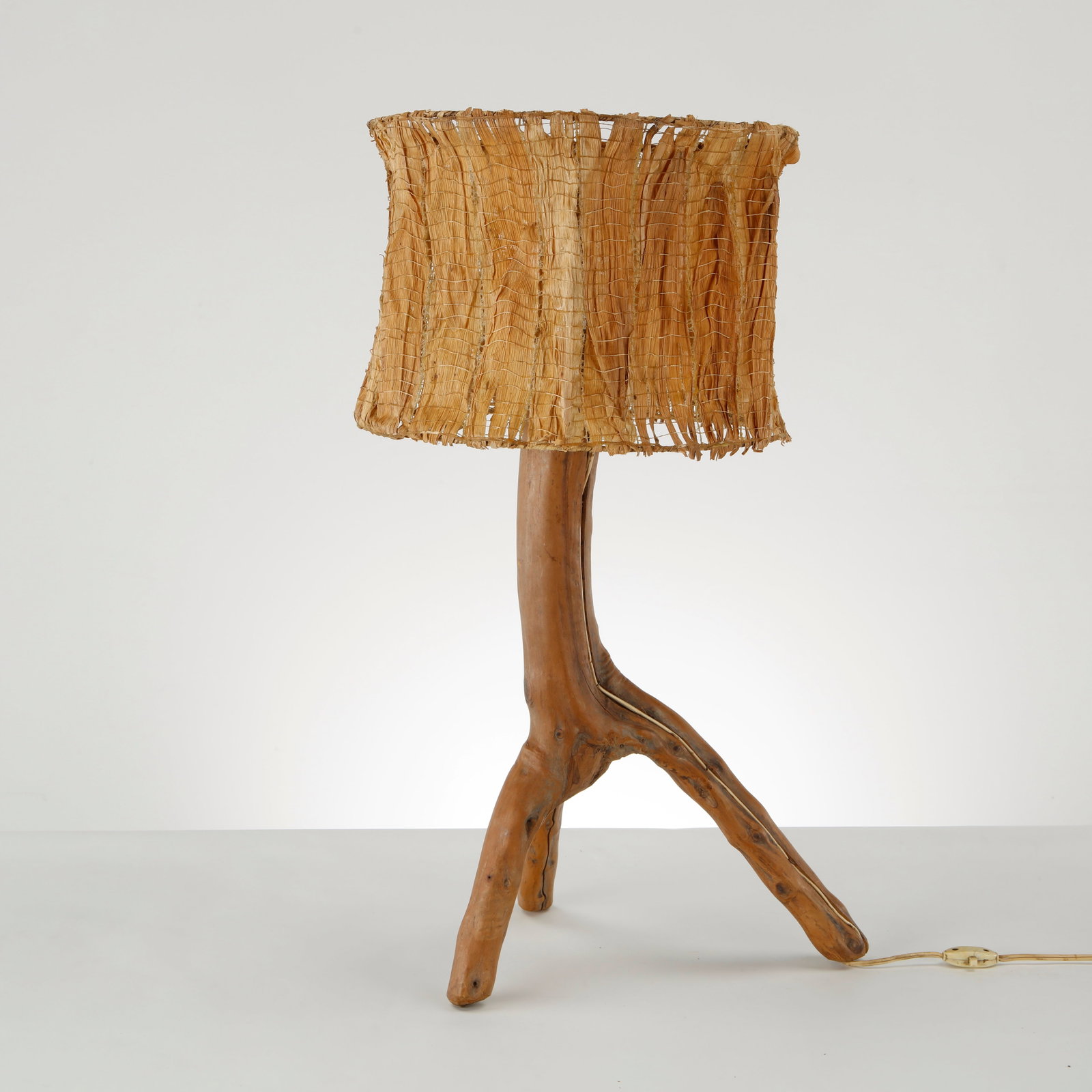 Brutalist Driftwood Table Lamp, France, 1950s: Executed with a naturally sculpted driftwood base and a woven fiber shade, this lamp reflects brutalist affinity for organic forms and handcrafted materials. A refined example of French naturalist