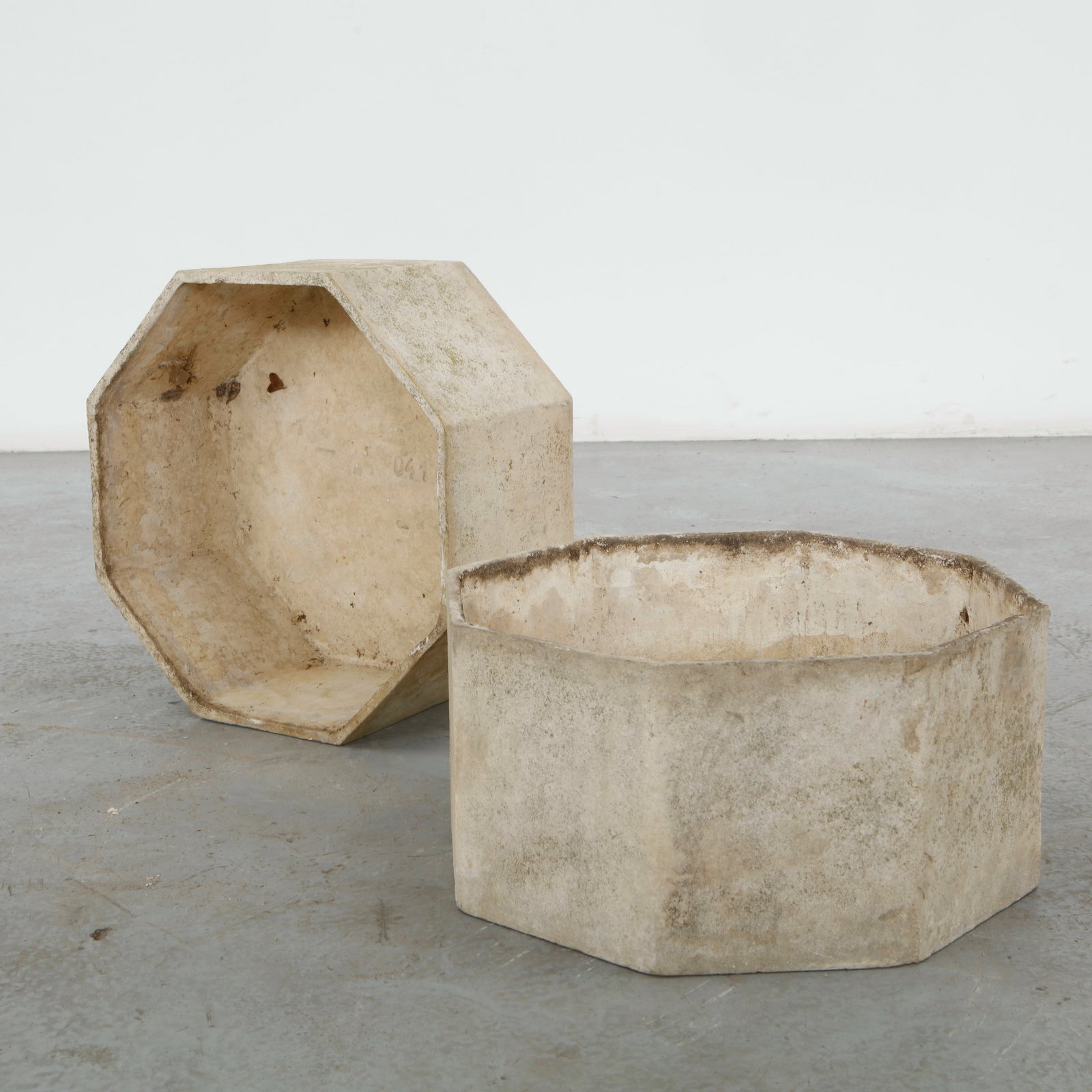 Willy Guhl, Pair of Hexagonal Planters, 1960s: Crafted in fiber cement, this pair of hexagonal planters exemplifies Willy Guhl restrained approach to sculptural outdoor design. Their faceted geometric form and naturally weathered surface