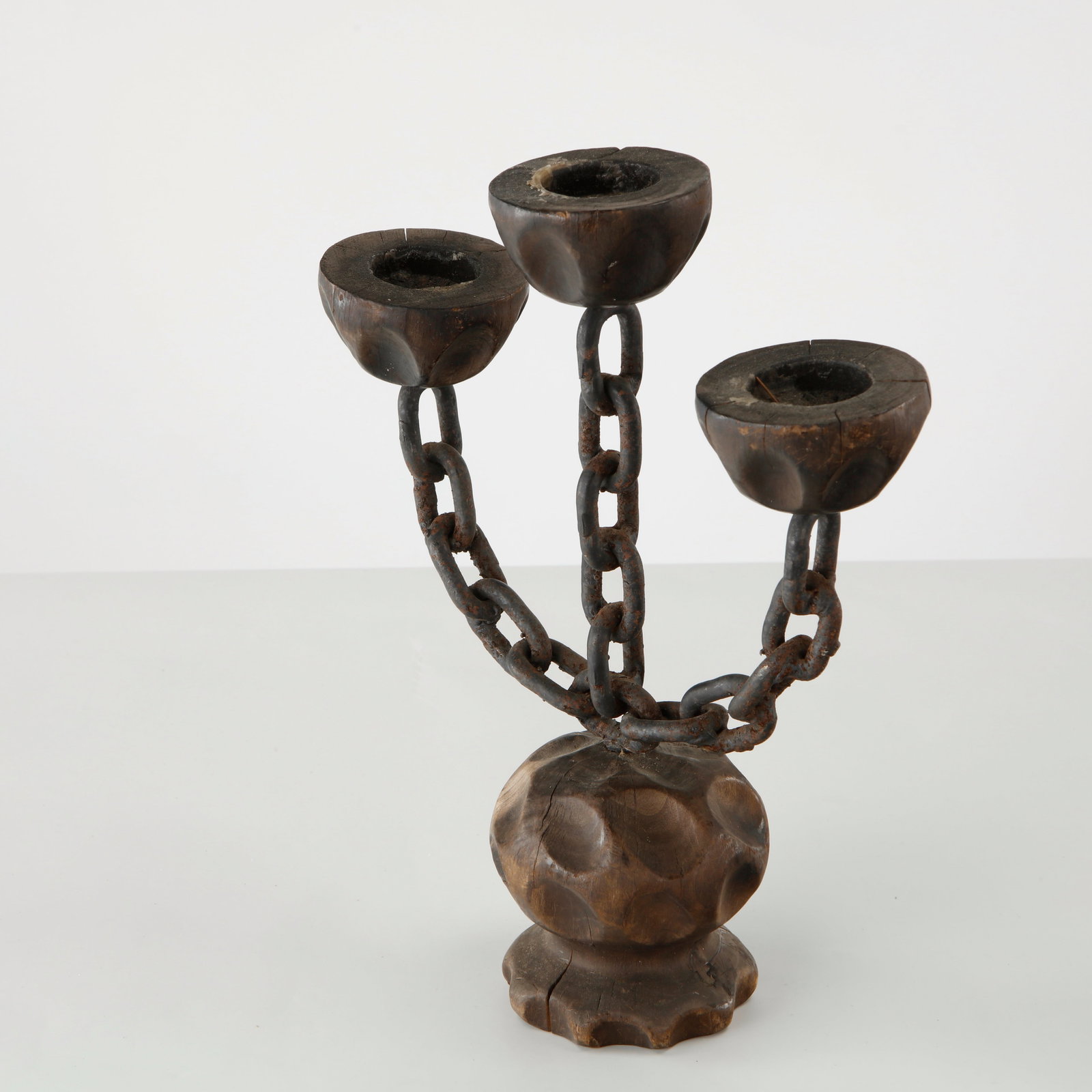 Brutalist Three Arm Candlestick, France, 1960s: A sculptural three-light candlestick combining hand-carved wood with forged iron chain elements. The expressive composition reflects the bold craftsmanship and organic aesthetic associated with the