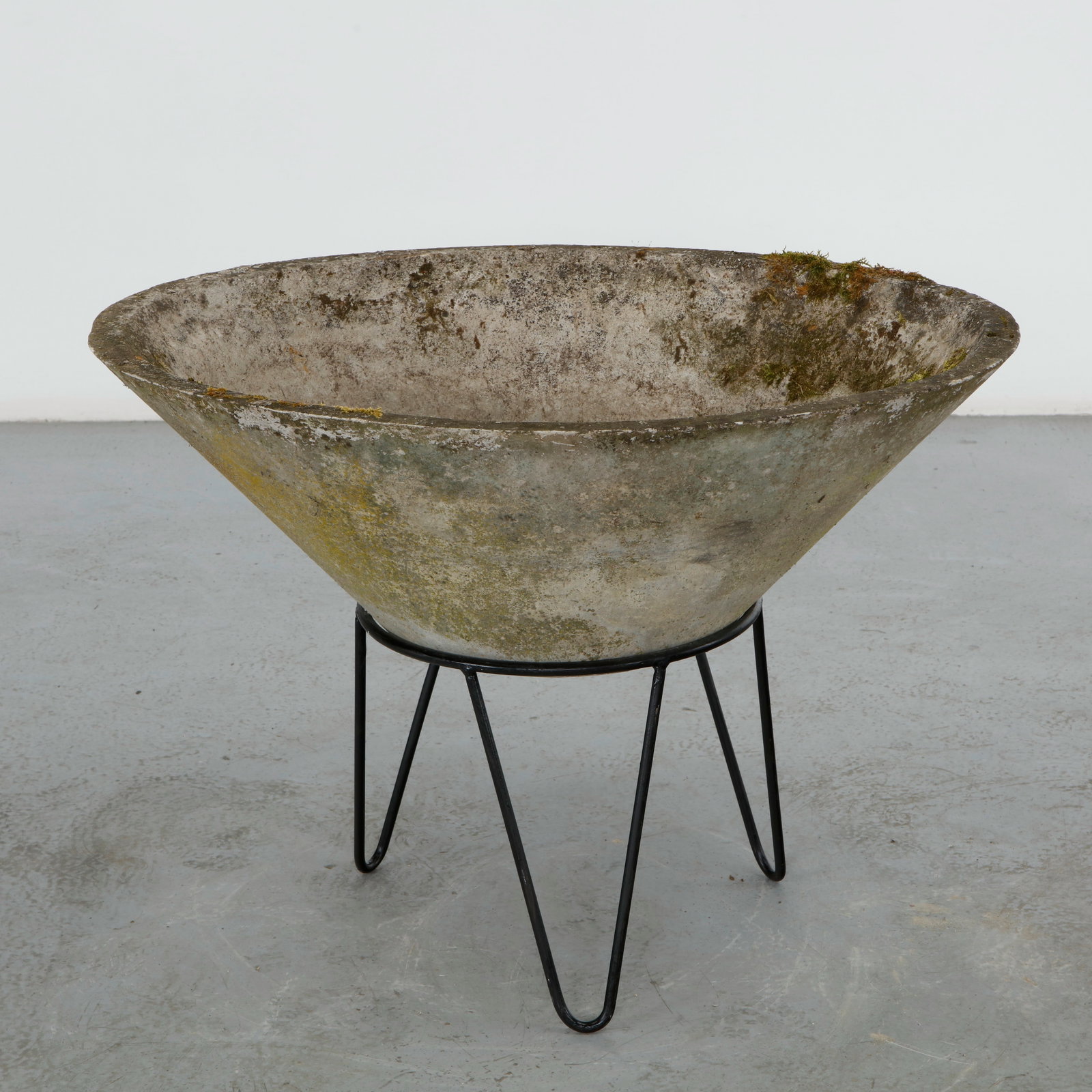 Willy Guhl, Oval Planter on Metal Stand, 1960s: A wide, oval bowl planter in fiber cement, raised on its original slender three legged iron stand. Weathered rim with dense moss and lichen accumulation over a grey cream body. Height: 11 in. Length: