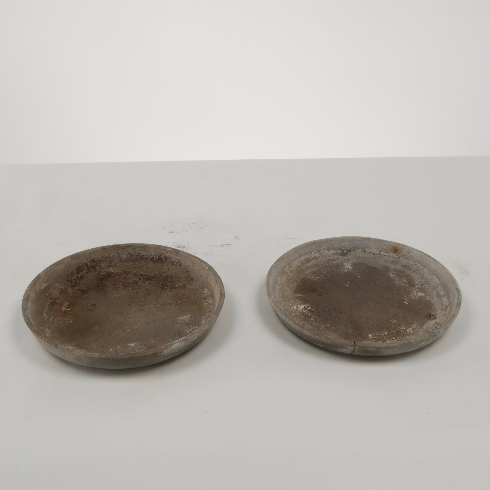 Willy Guhl, Pair of Saucers, Switzerland, 1960s: A pair of original fiber cement saucers by Willy Guhl, distinguished by their understated form and beautifully weathered patina. Designed to accompany the designer iconic planters, they also serve as 