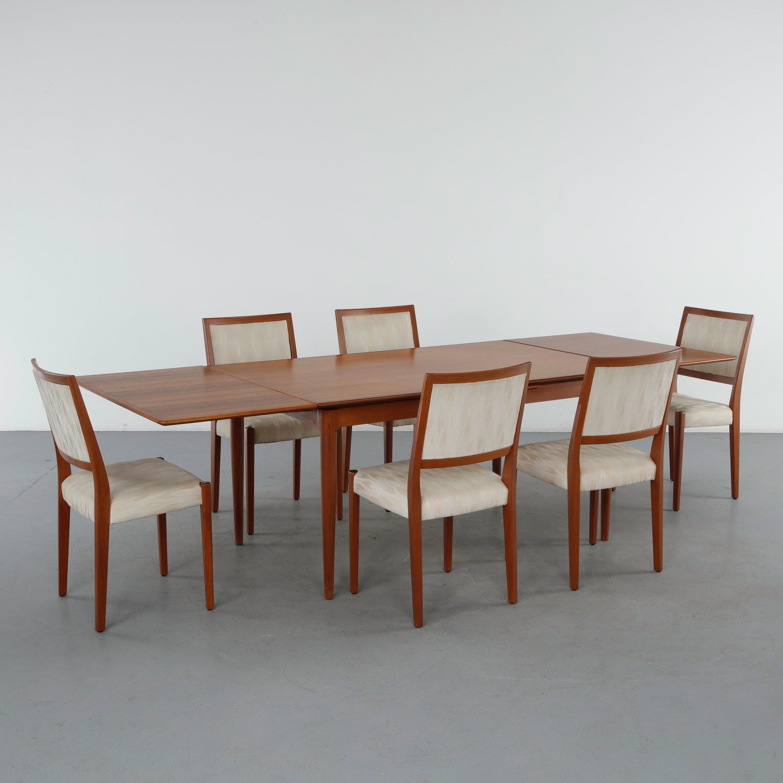 Johannes Andersen for Uldum Mobelfabrik, Extendable Teak Dining Table with Six Svegards Dining: Elegant Danish dining set comprising an extendable teak dining table by Johannes Andersen for Uldum M0belfabrik and a set of six Svegards dining chairs. Beautifully figured teak, sculpted edges, and g