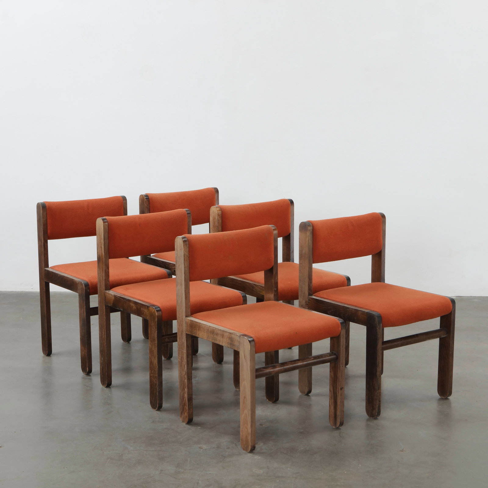 Set of Six Modernist Dining Chairs in Orange Wool, 1970s: A bold set of six mid-century dining chairs featuring vibrant orange wool upholstery and dark stained wood frames. Their clean lines and rich color lend sophistication to any modern interior. Height: 