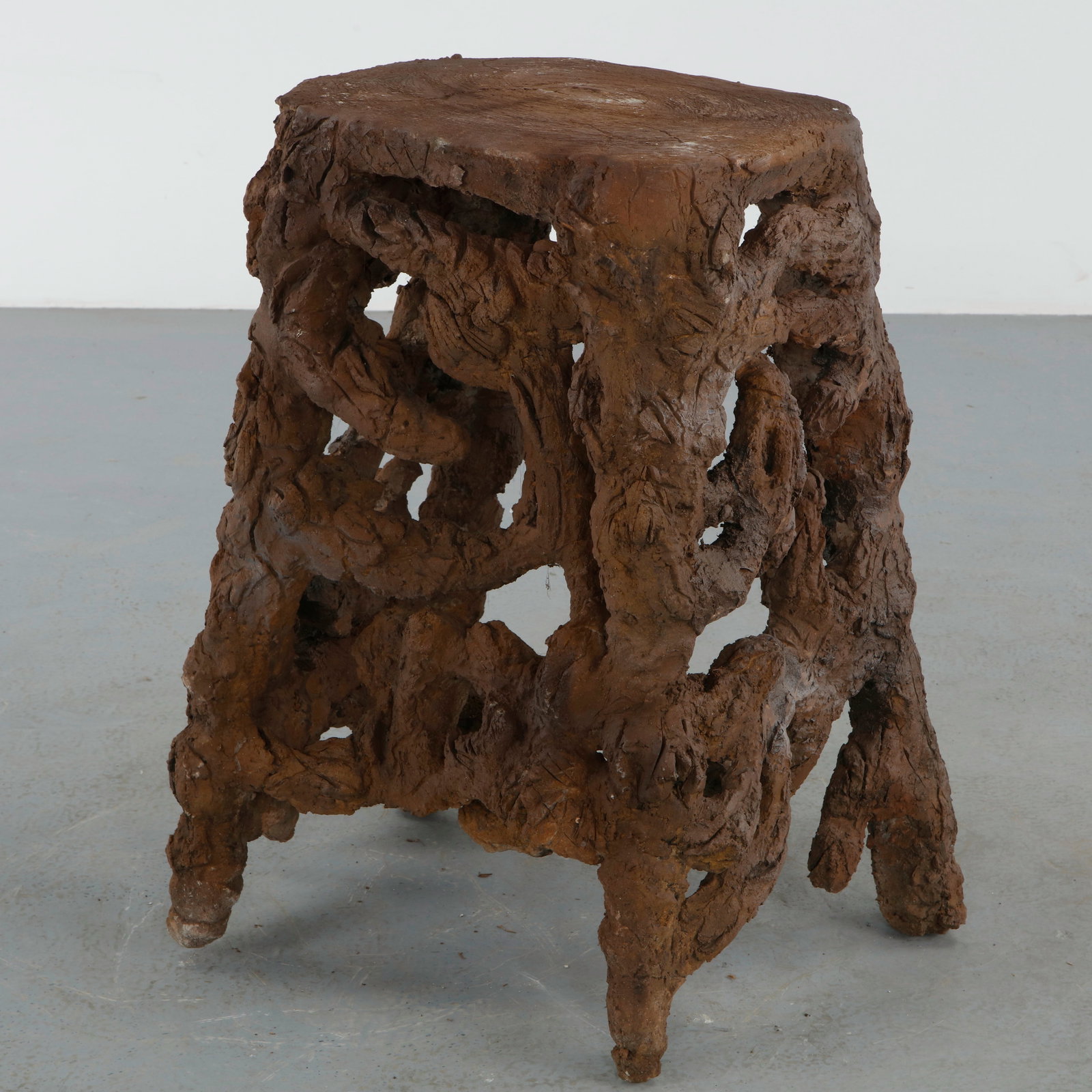 Sculptural Faux Bois Side Table: Sculptural faux bois side table executed with heavily textured organic forms beneath a circular top imitating carved wood grain. The compact silhouette embodies the whimsical character of rustic garde