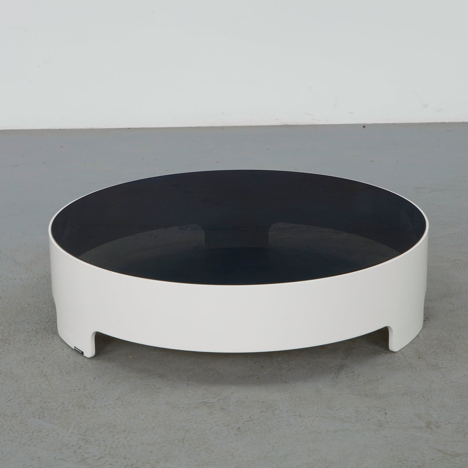 Daniel Rode for Roche Bobois, Cuba Libra Circular Mirror Coffee Table, France, 2000s: Designed by Daniel Rode for Roche Bobois, this Cuba Libra coffee table features a sculptural circular lacquered base supporting a smoked mirrored glass top. The restrained geometry and reflective surf