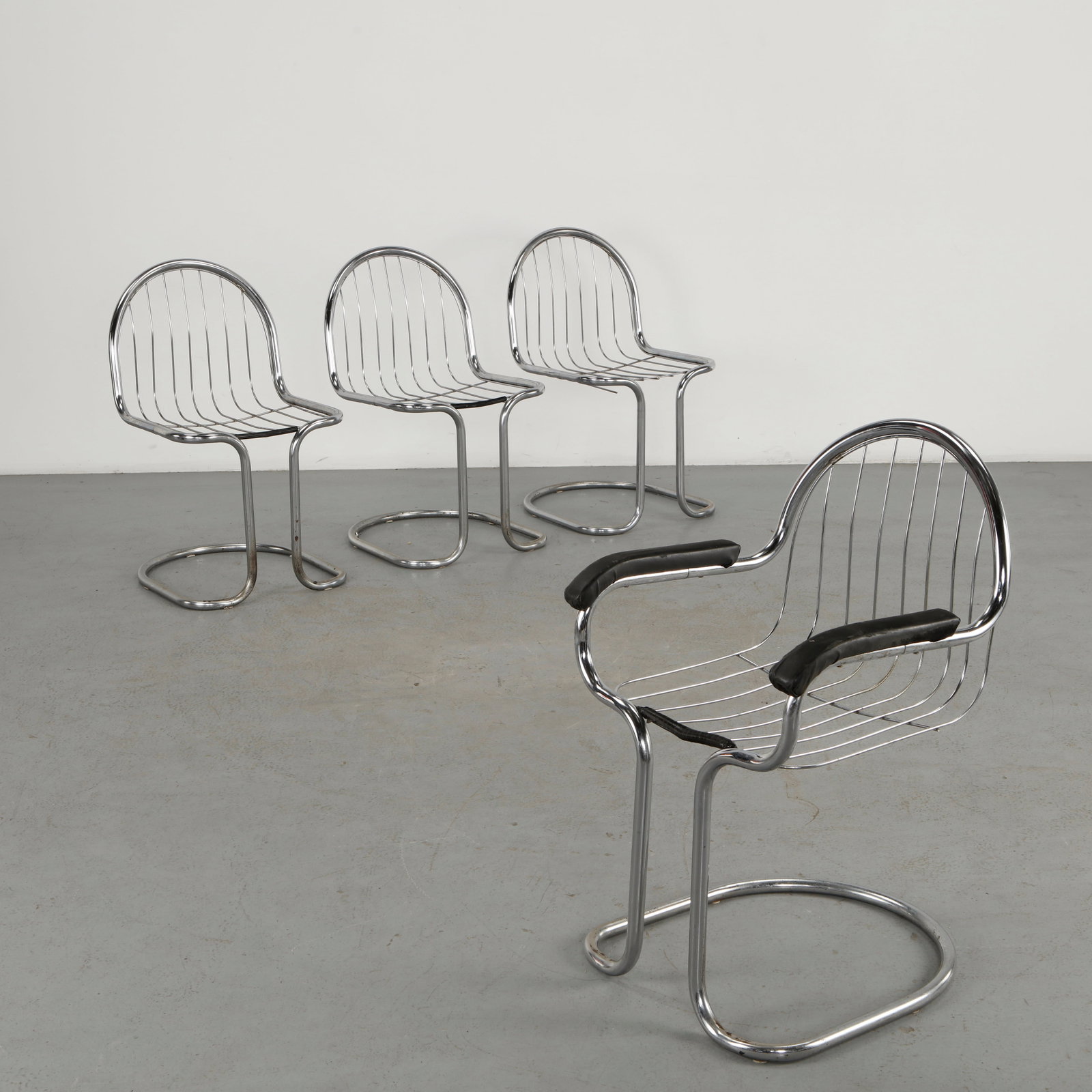 Willy Rizzo, Set of Four Chrome Wire Chairs, 1970s: A striking set of four chrome-plated wire armchairs by Willy Rizzo, featuring sculptural sled bases and openwork metal seats and backs. The polished tubular construction and restrained upholstery