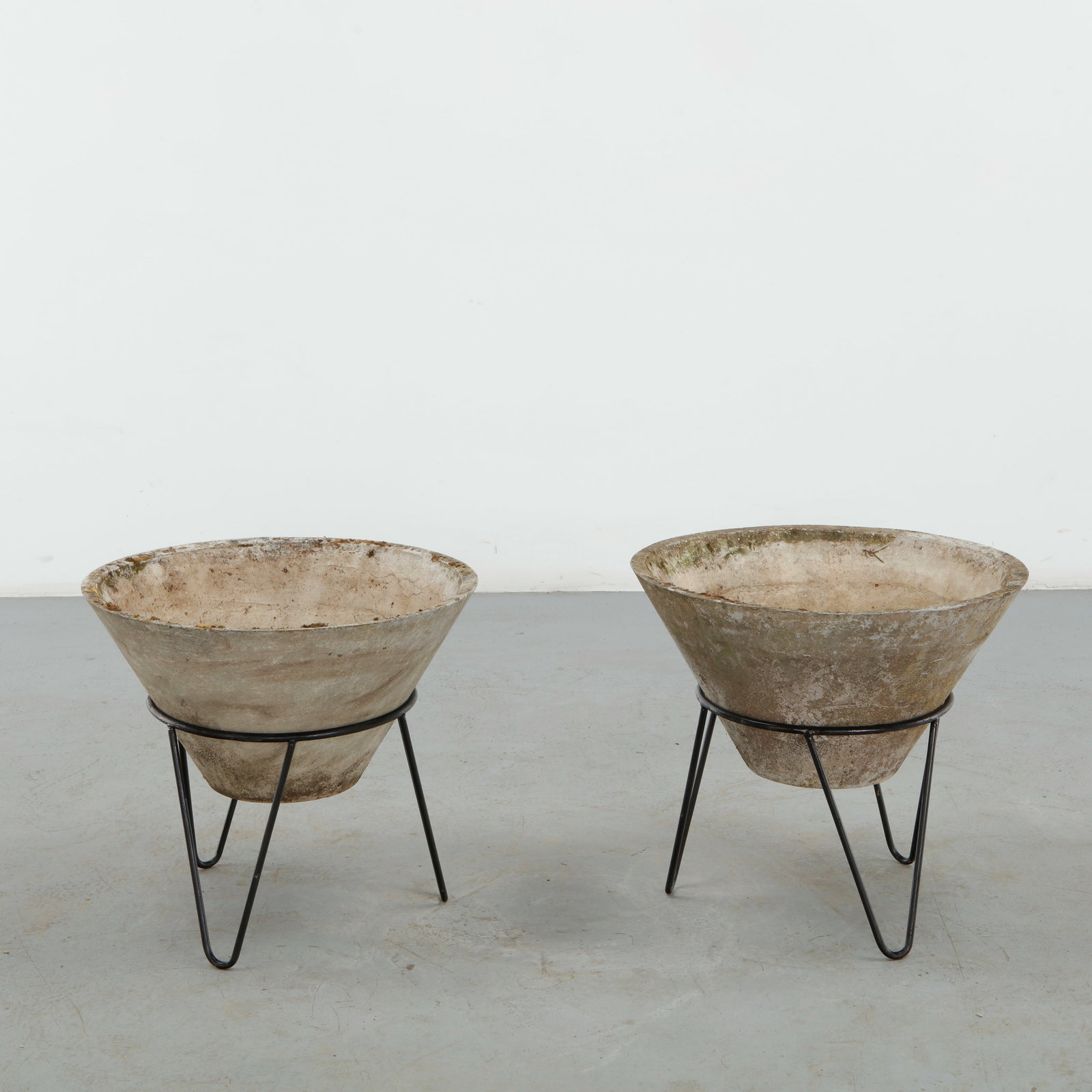 Willy Guhl, Pair of Conical Planters on Stands, 1960s: Iconic Willy Guhl silhouettes in compact form, these conical planters rest atop minimalistic metal stands, weathered yet timeless. Height: 19.5 in. Diameter: 22 in.