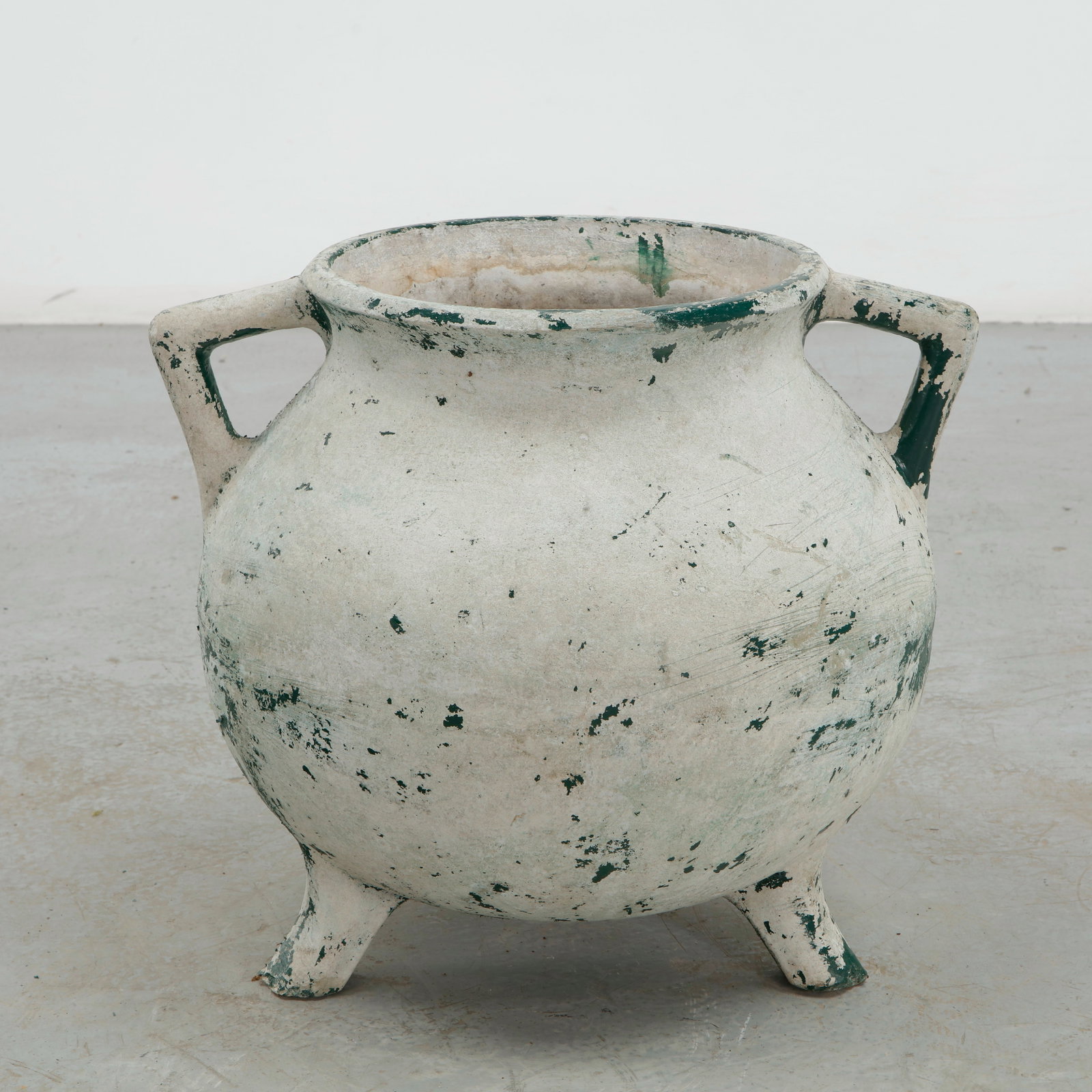 Willy Guhl, Cauldron Planter, 1960s: Executed in fiber cement, this cauldron form planter features two loop handles and raised tripod feet beneath a green painted finish. Losses to the surface reveal the pale material beneath, adding