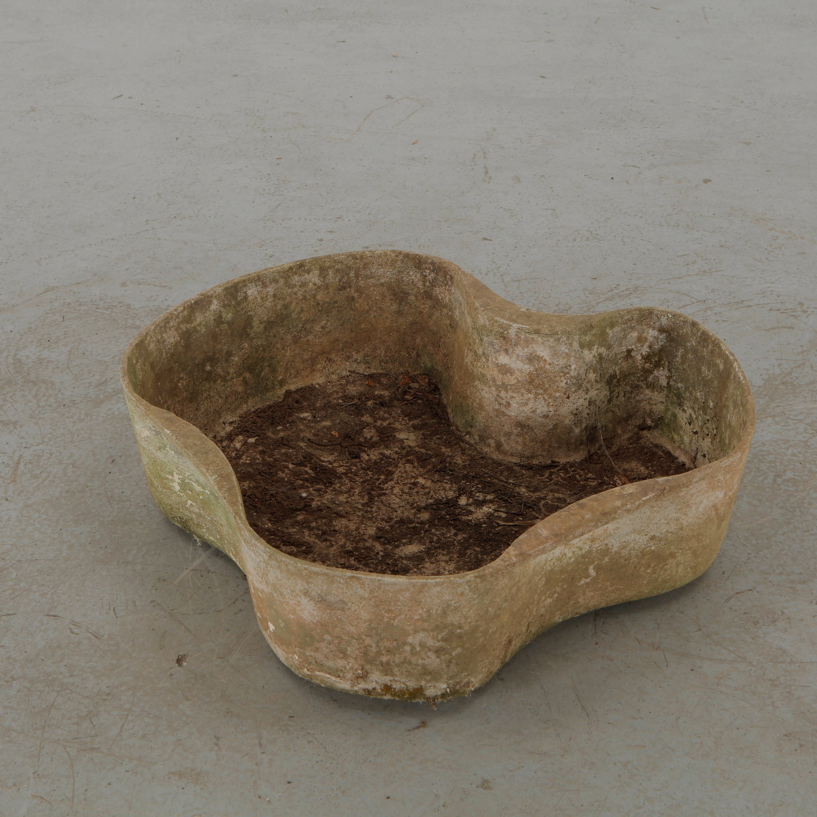 Willy Guhl, Freeform Planter, 1960s: A sculptural freeform concrete planter characterized by its softly articulated, organic silhouette. Weathered through decades of outdoor exposure, the mottled surface and naturally developed patina