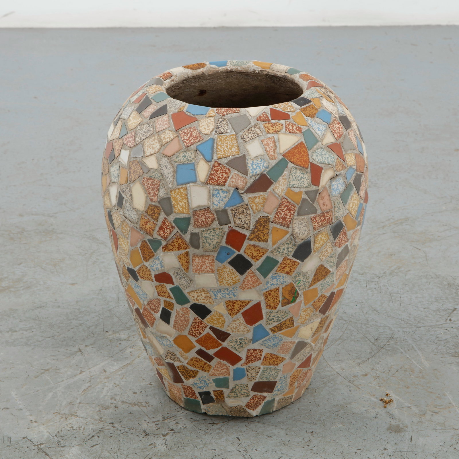 Mosaic Concrete Planter, 1960s: Decorative concrete planter of rounded, organic form, entirely clad in hand-set fragments of brightly colored glazed tiles. The irregular mosaic surface combines warm terracotta, ochre, blue, green,