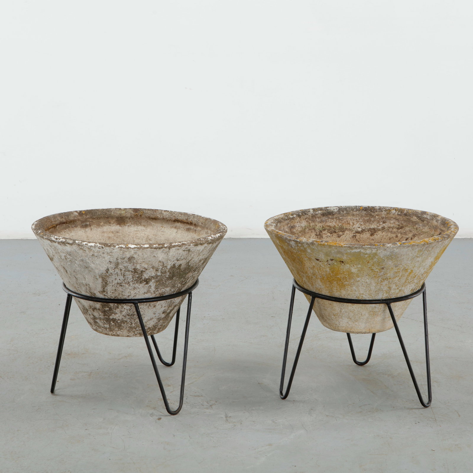Willy Guhl, Pair of Conical Planters on Stands, 1960s: Iconic Willy Guhl silhouettes in compact form, these conical planters rest atop minimalistic metal stands, weathered yet timeless. Height: 19.5 in. Diameter: 22 in.