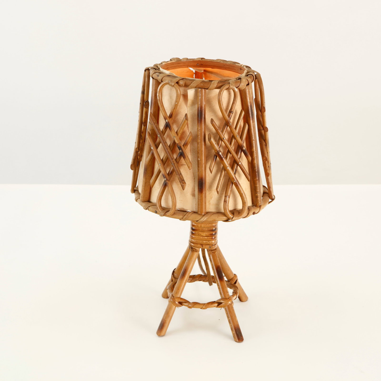 Louis Sognot, Rattan Tripod Table Lamp, 1960s: Sculptural rattan table lamp featuring a woven cylindrical shade raised on an articulated tripod base. The open construction and carefully curved elements create a delicate architectural silhouette, c